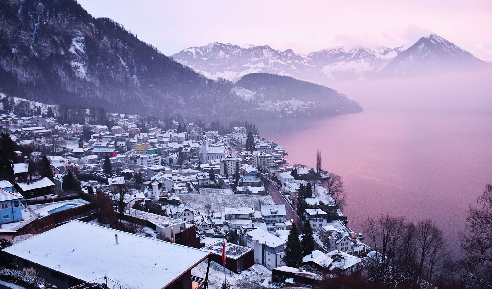 Schneebedeckte Seelandschaft mit Alpenort