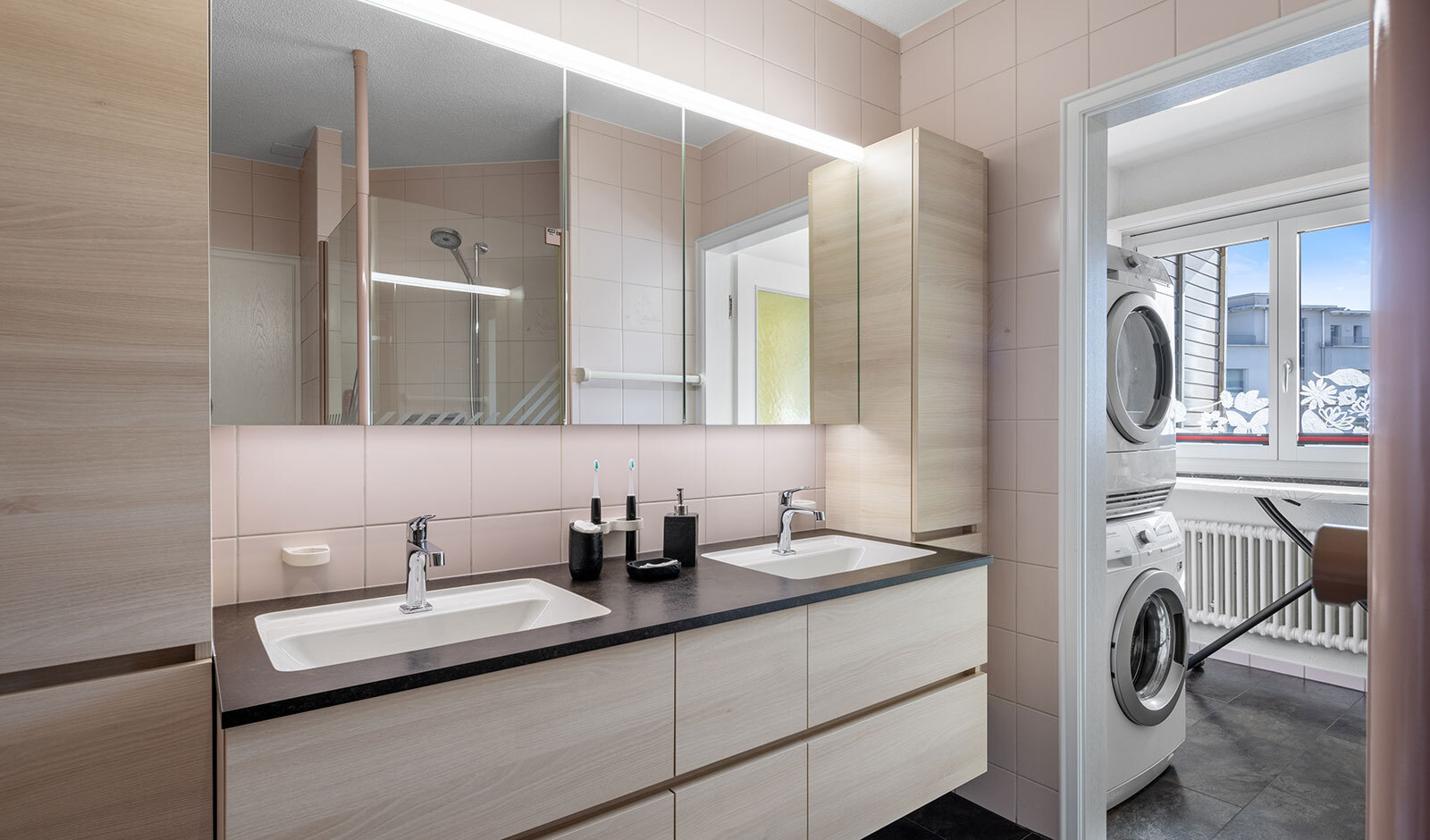 Modernes Badezimmer mit Doppelwaschbecken und Hauswirtschaftsraum