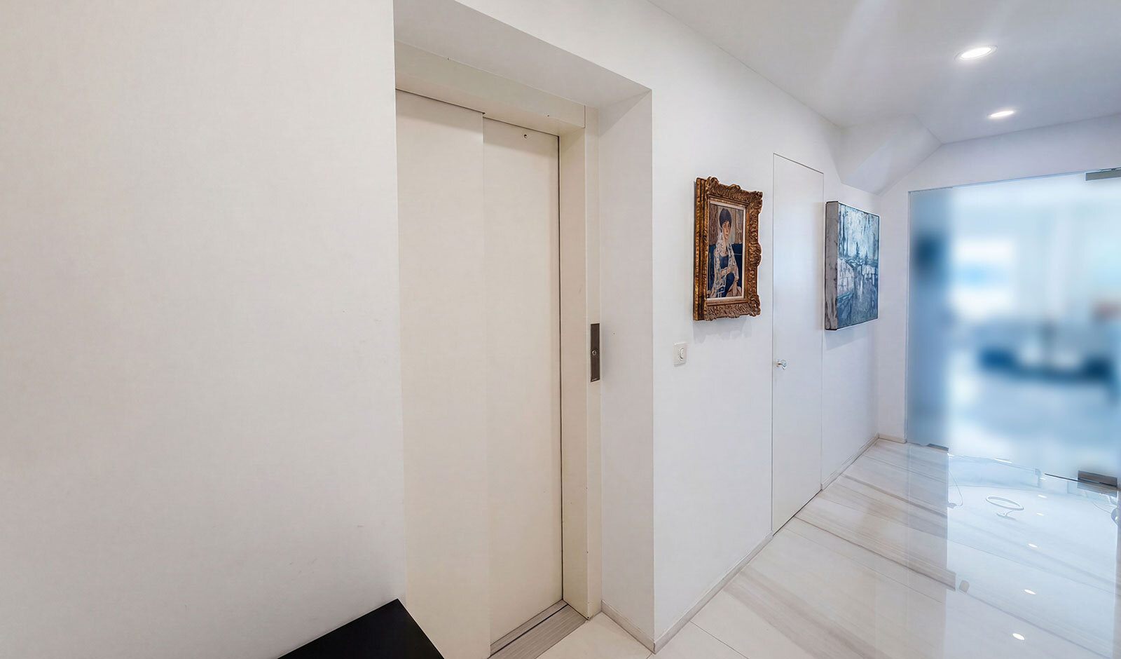 Heller Flur mit Aufzug und Glasfront