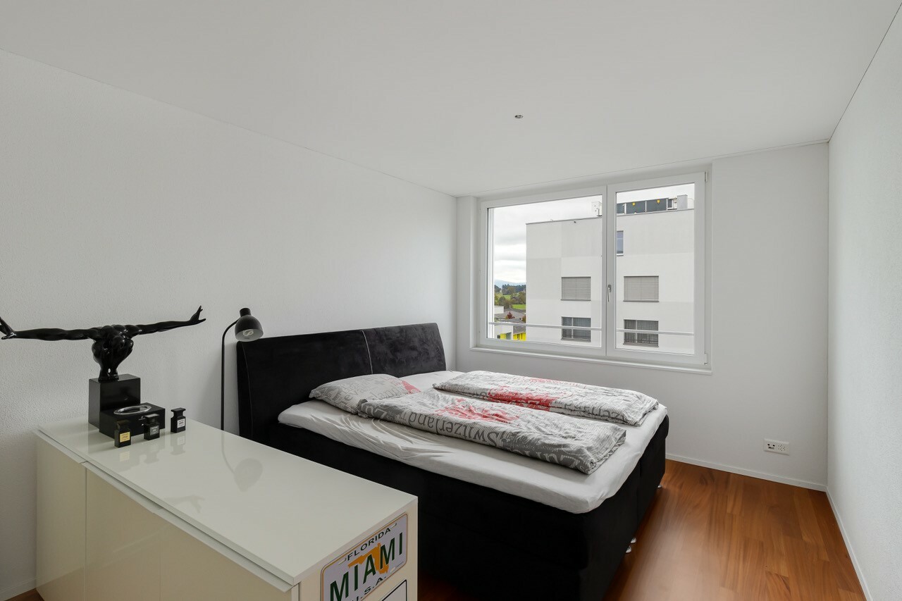 Helles Schlafzimmer mit Doppelbett und weißem Fenster