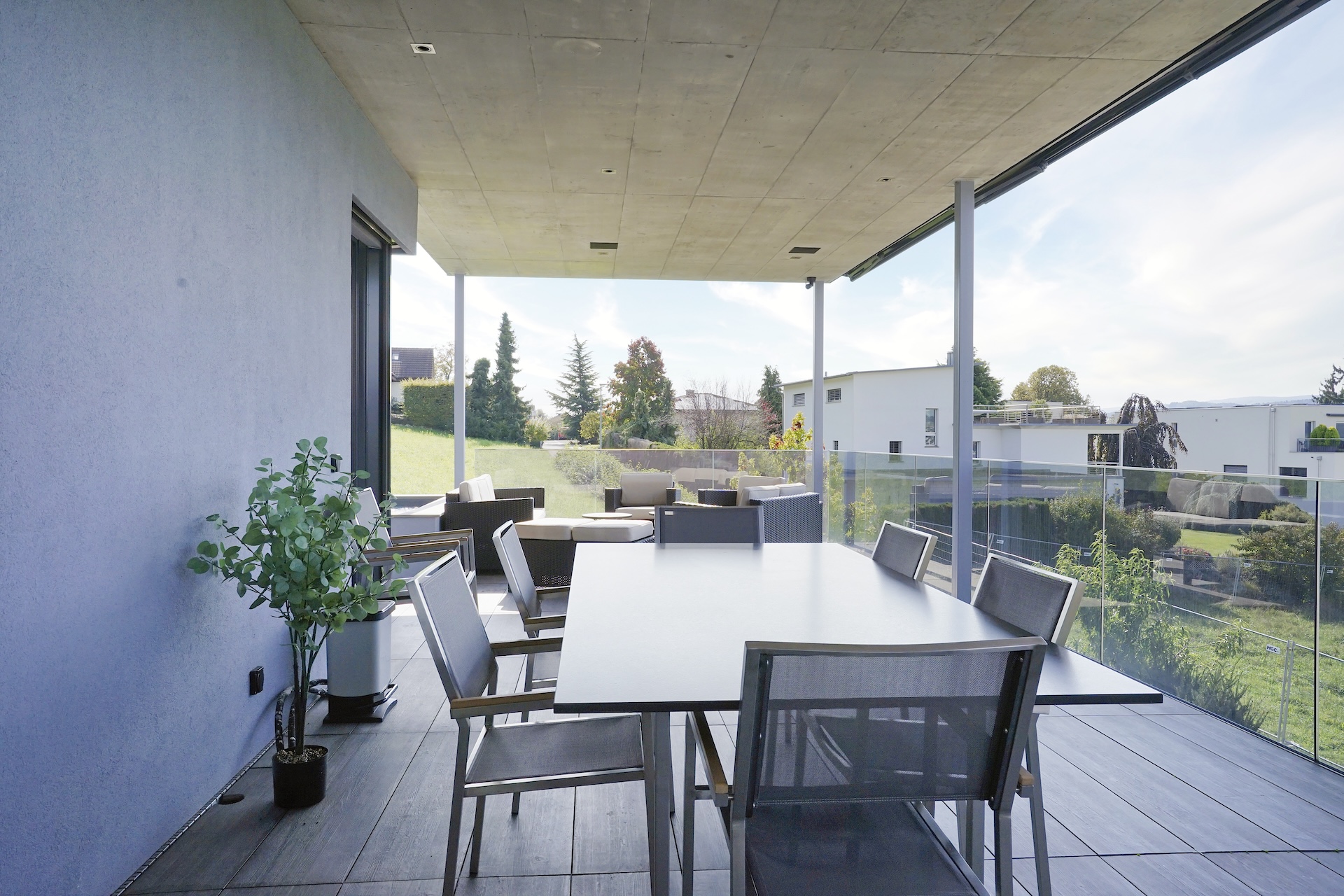 Moderne überdachte Terrasse mit Gartenblick