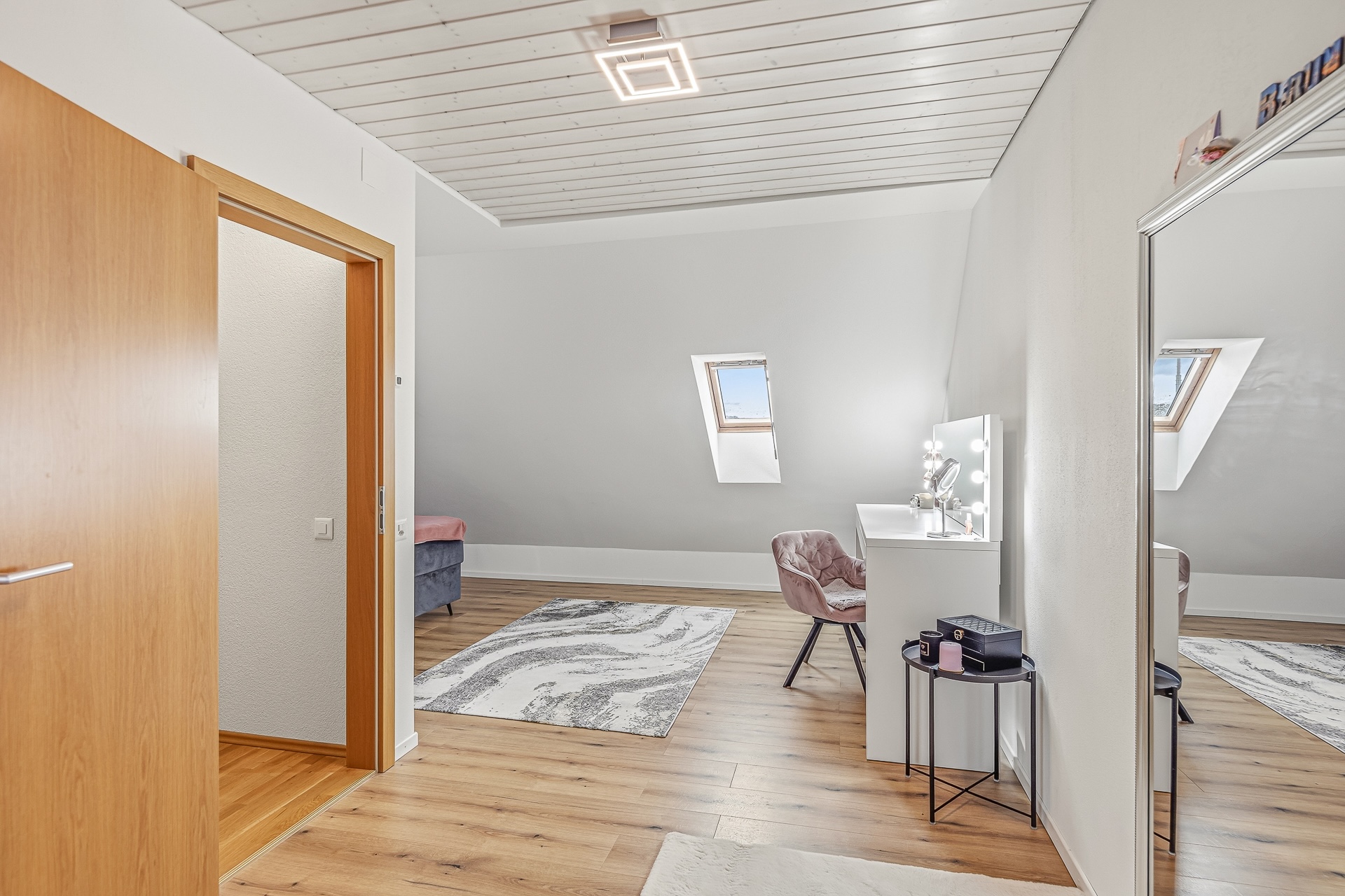 Helles Dachzimmer mit Dachfenster und Schminktisch