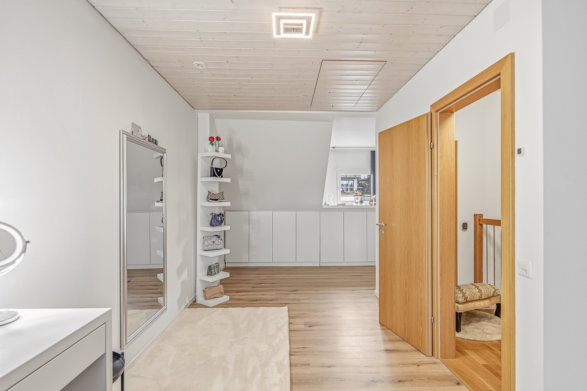 Heller Flur mit Holzdecke und Ankleidebereich