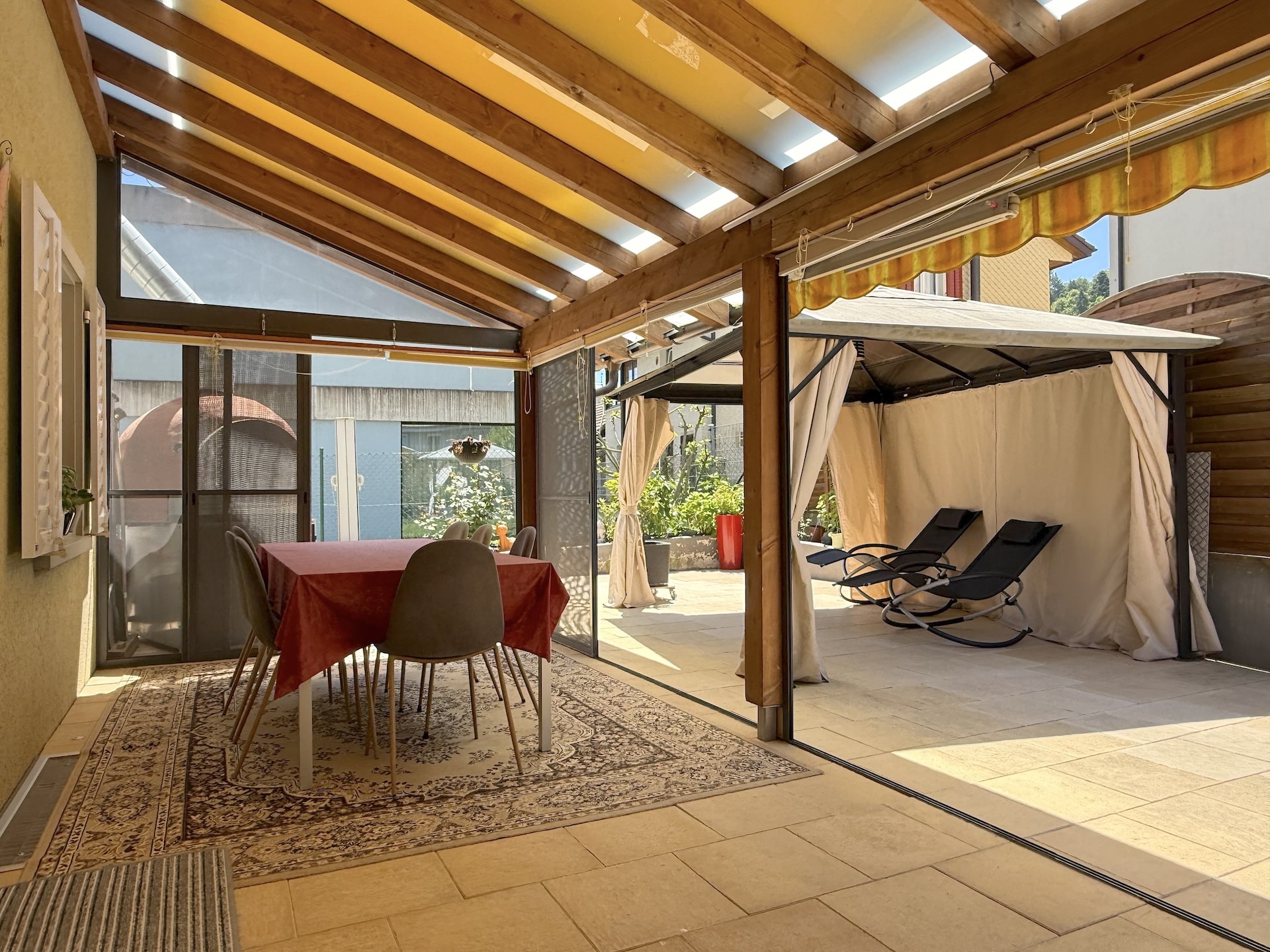 Überdachte Terrasse mit Essbereich und Lounge