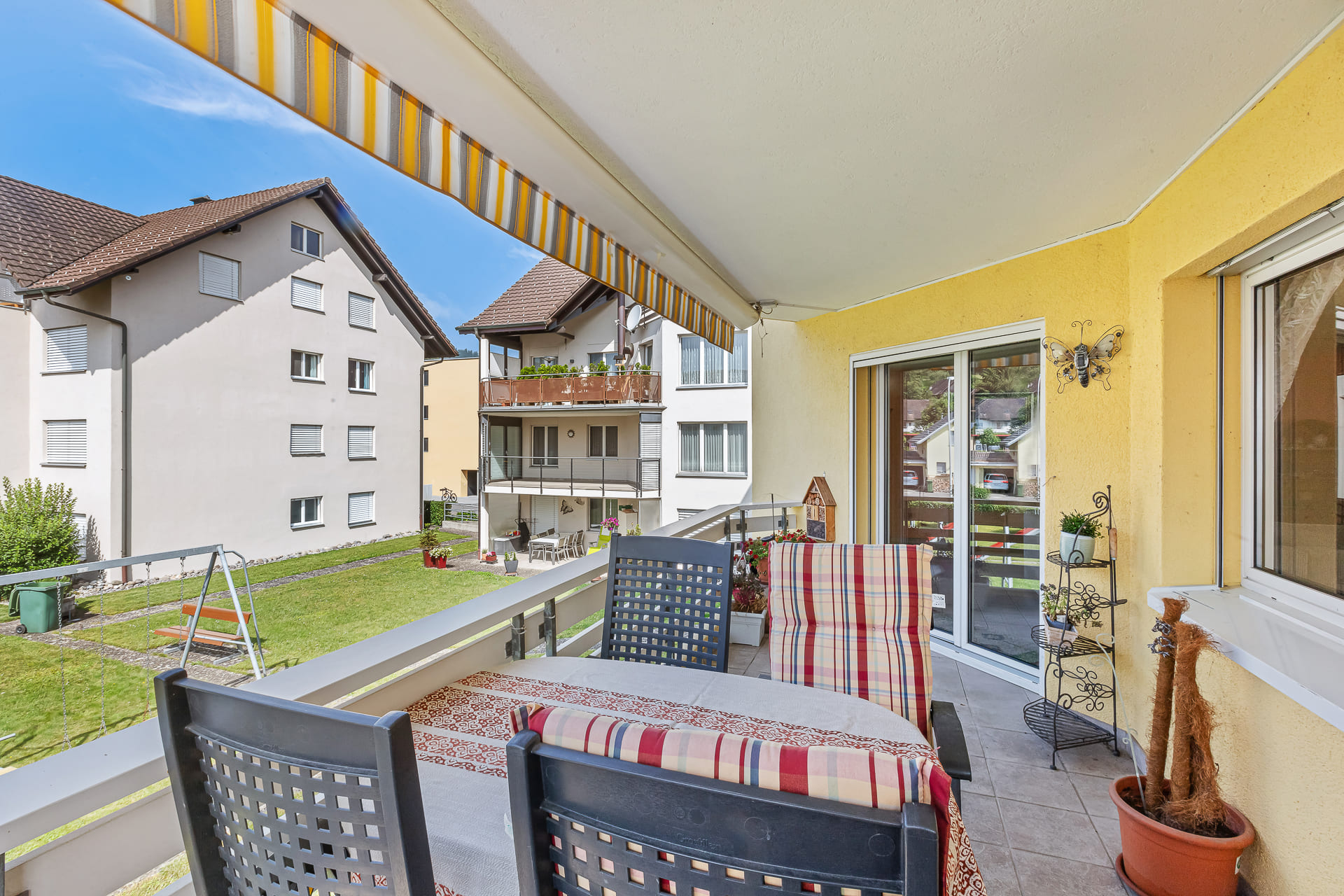 Überdachter Balkon mit Blick auf Innenhof und Nachbargebäude
