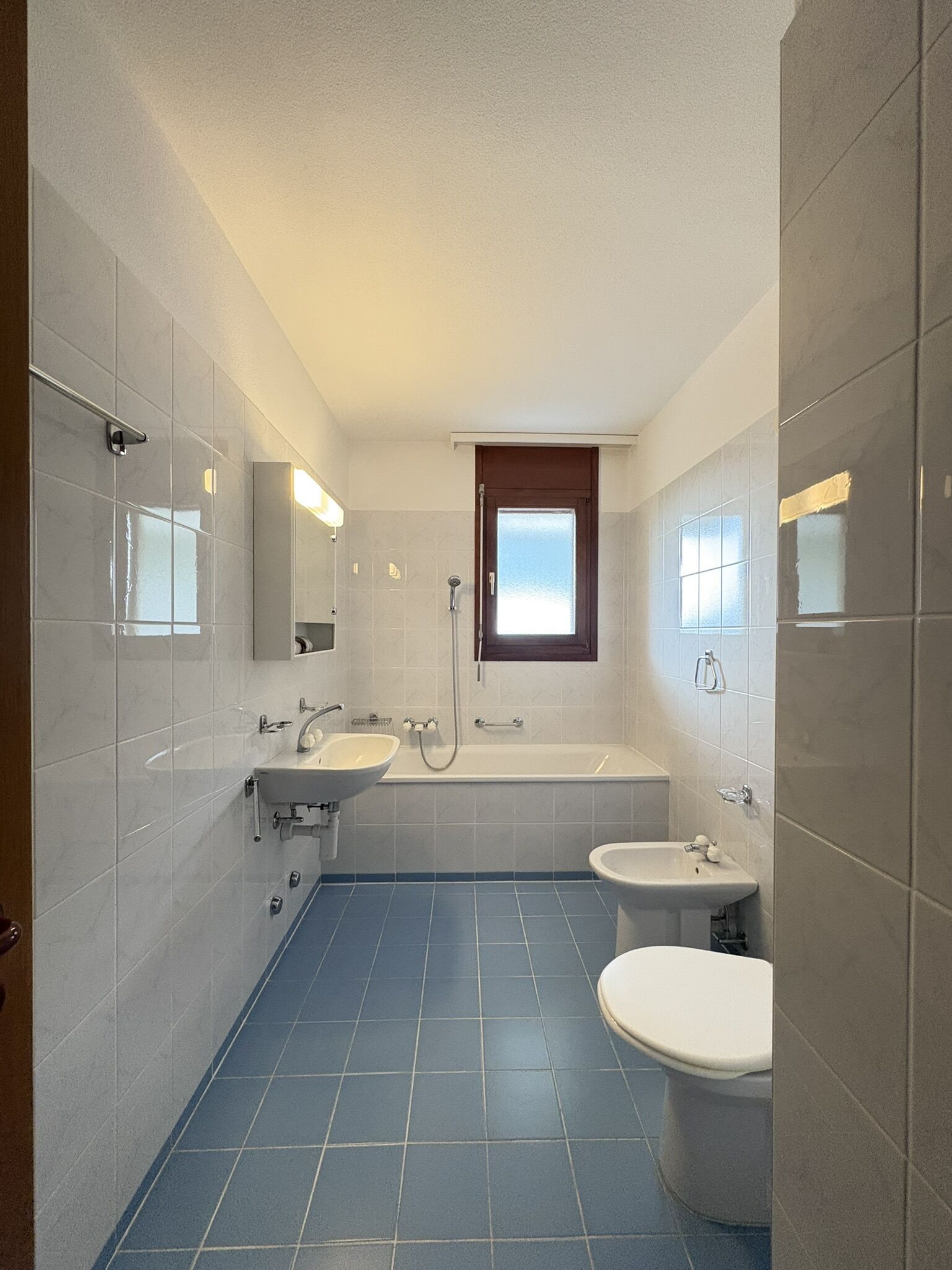 Badezimmer mit Badewanne, zwei Waschbecken und WC