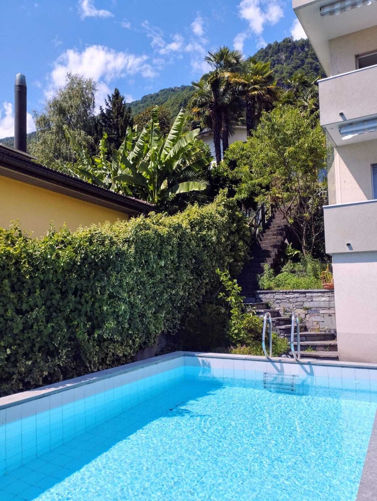Poolbereich mit üppiger Bepflanzung und Bergkulisse
