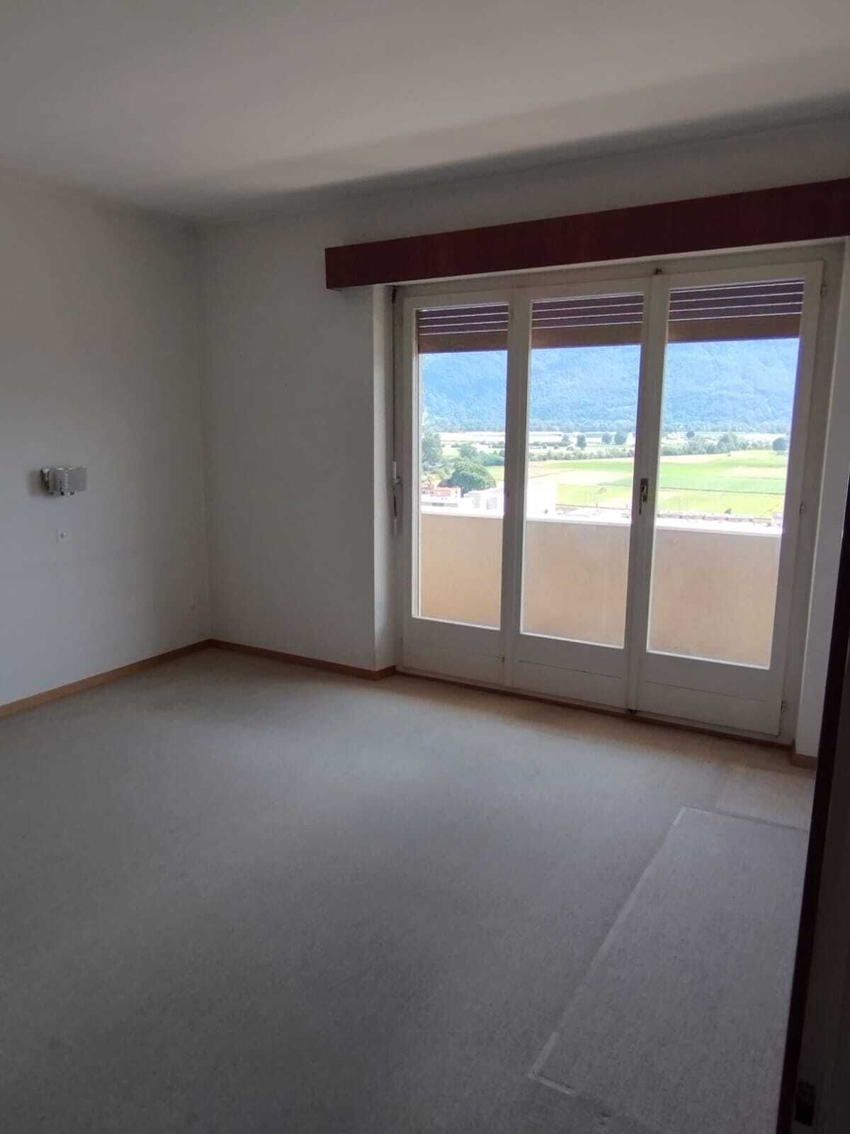 Helles, leeres Zimmer mit Balkonblick