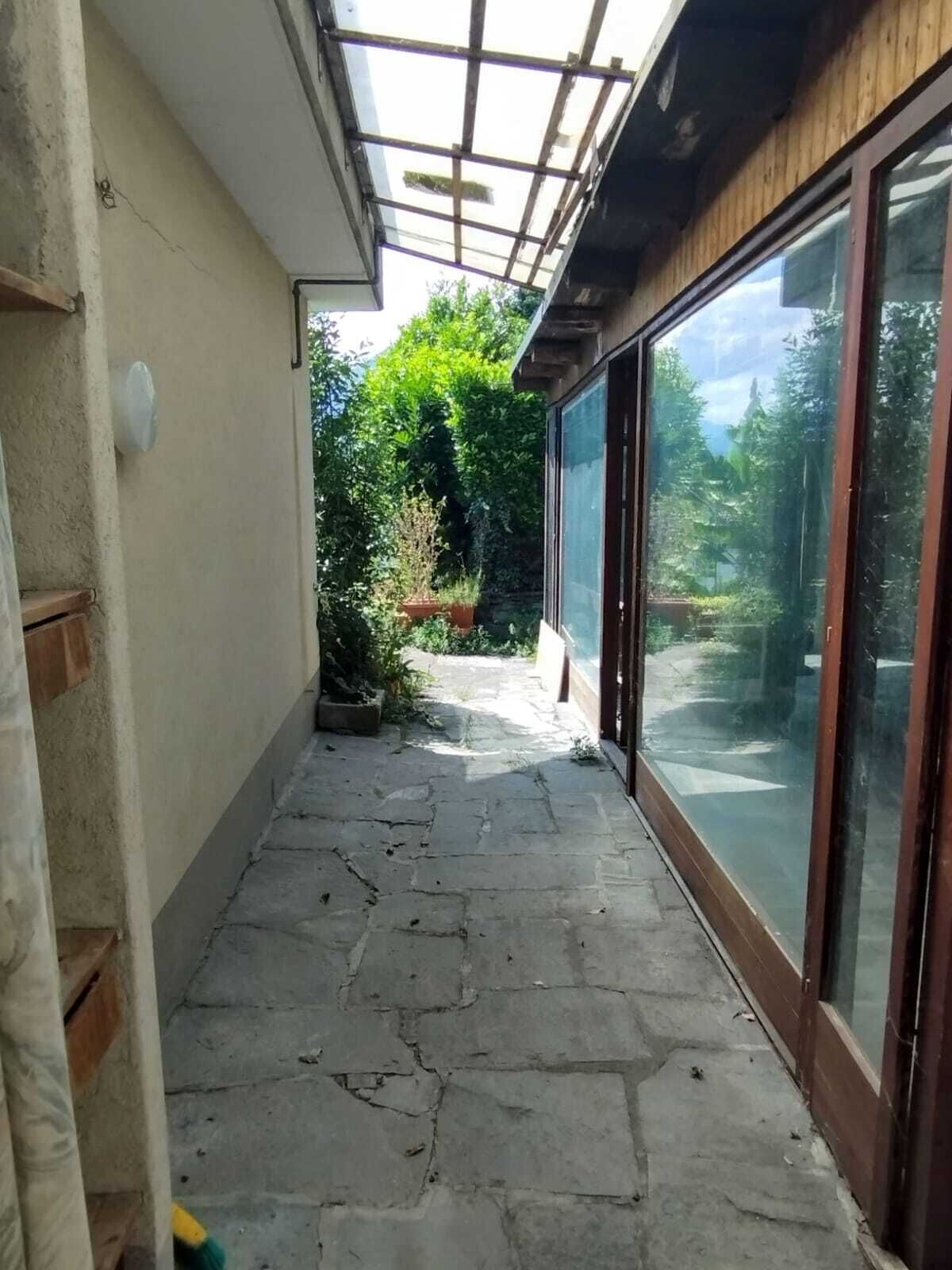 Überdachter seitlicher Außenbereich mit Glasfront
