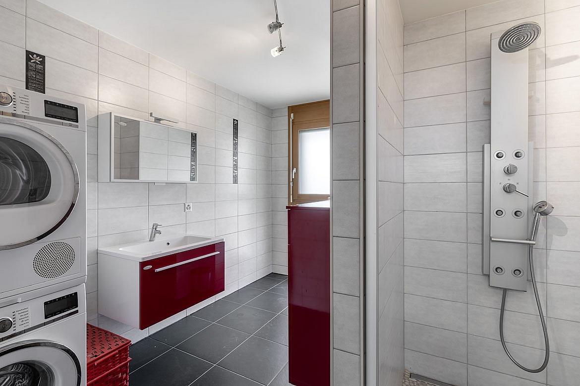 Modernes Badezimmer mit Waschbereich und Duschzone