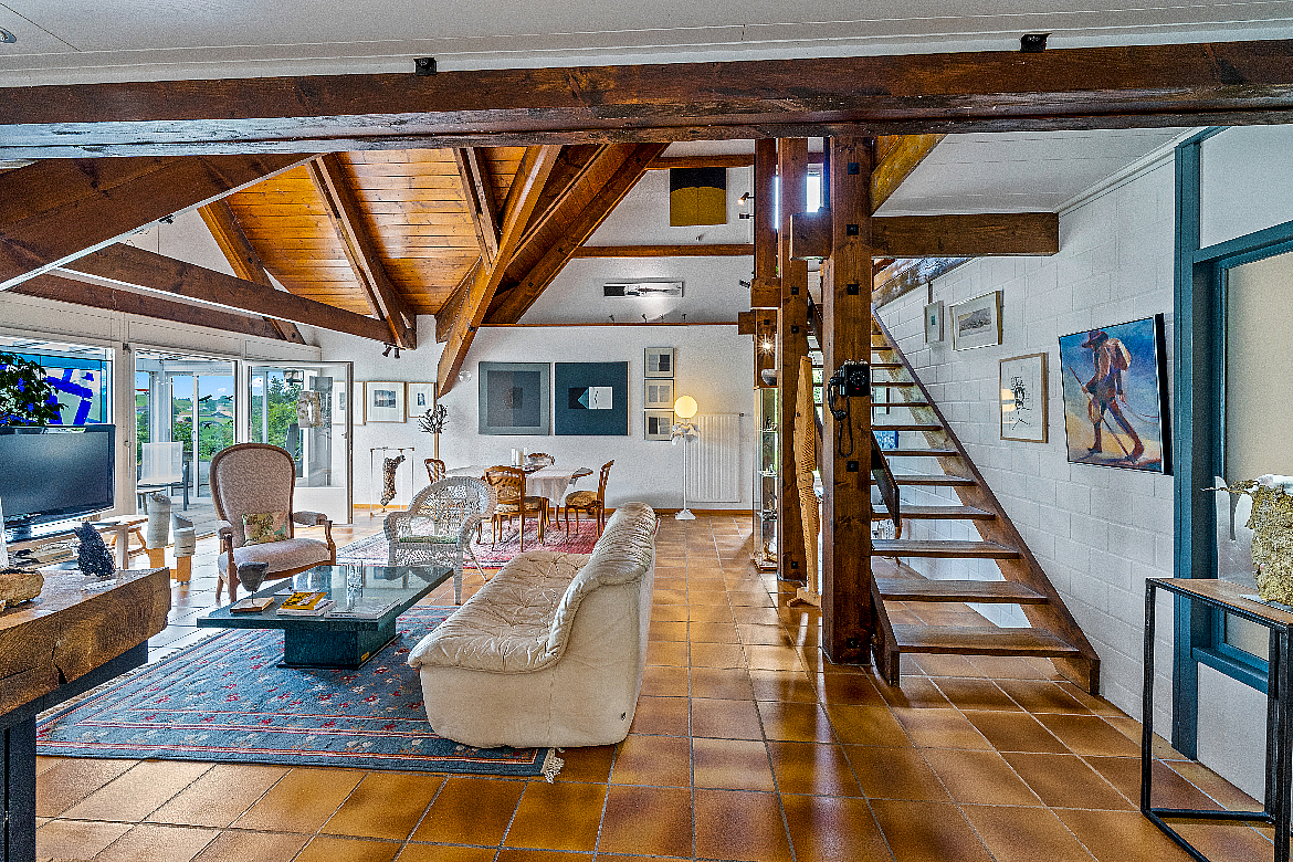 Wohnzimmer mit offener Galerie und Holztreppe