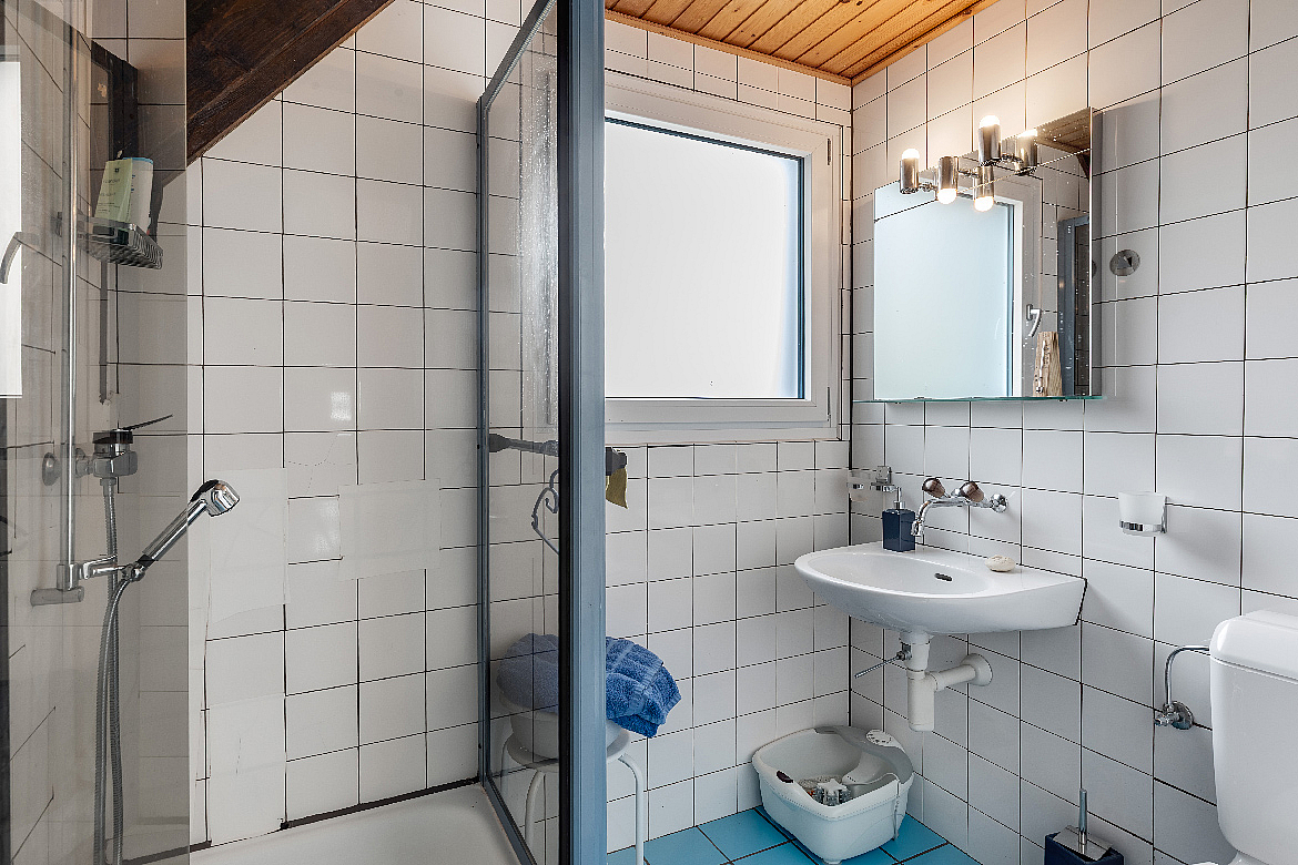 Kleines Badezimmer mit Dusche und Waschtisch