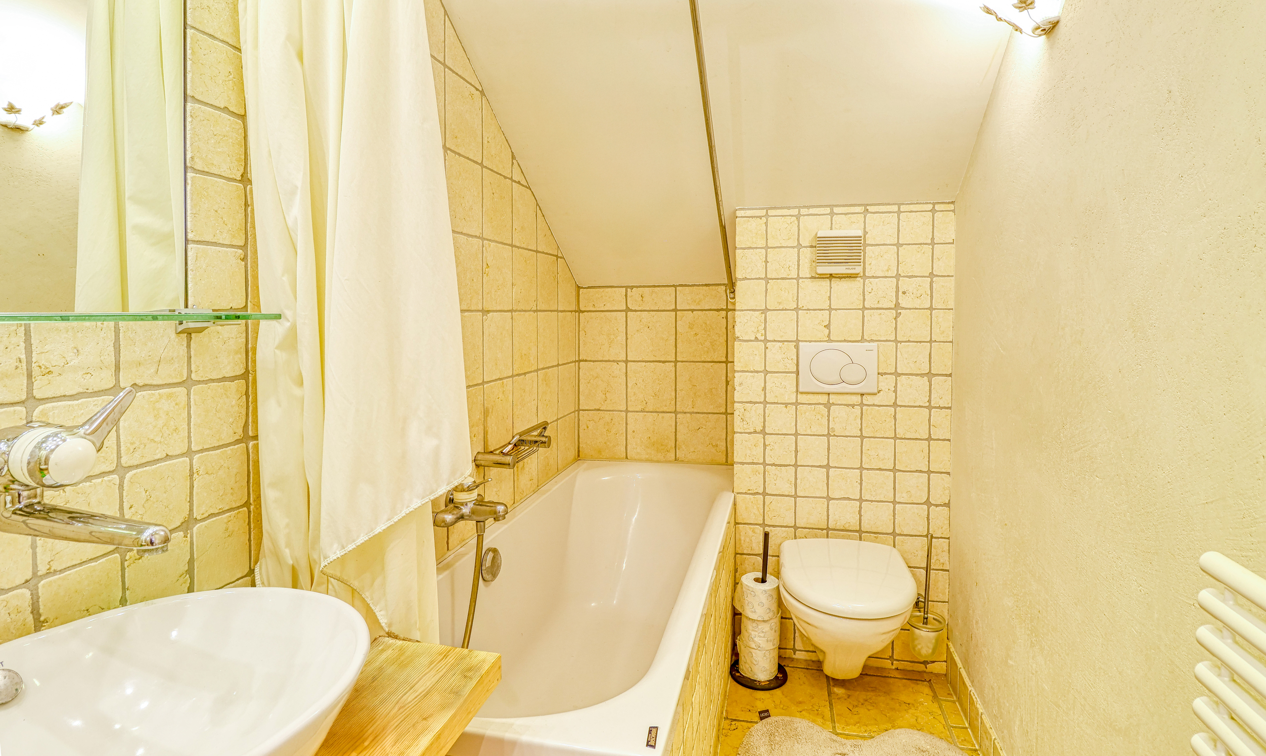 Kleines Badezimmer mit Badewanne und WC