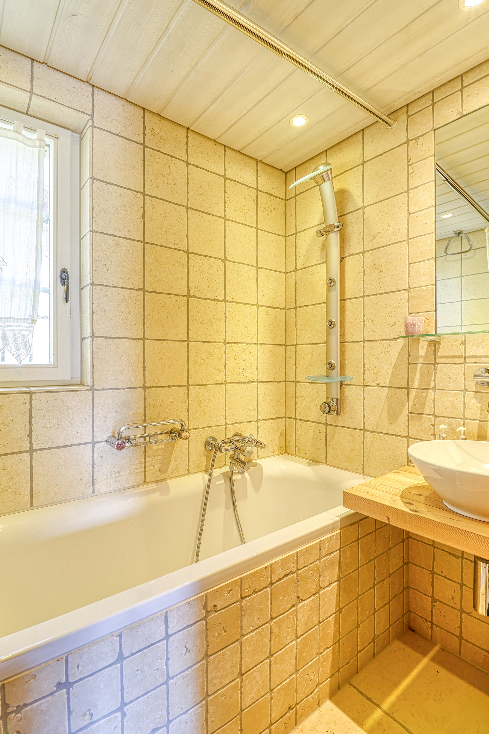 Badezimmer mit Badewanne und Natursteinfliesen