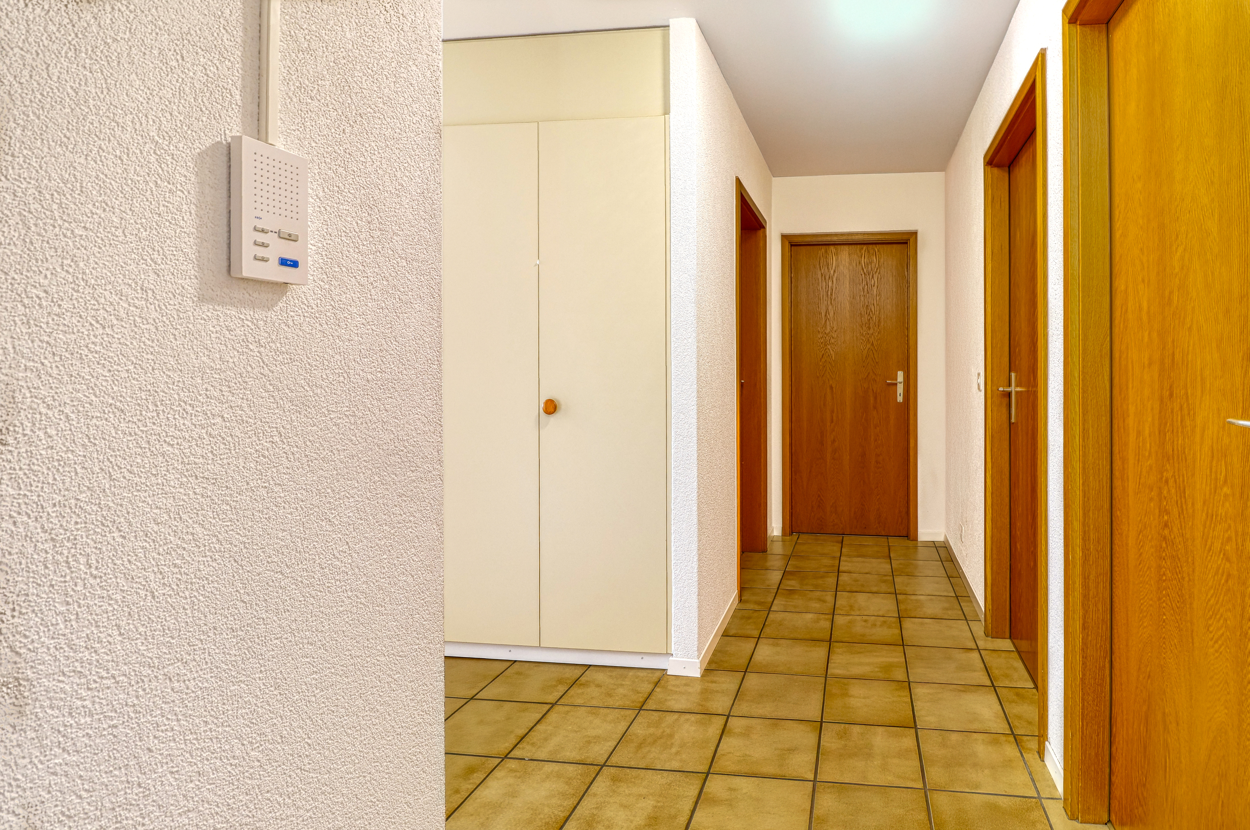 Heller Flur mit Fliesenboden und Holztüren