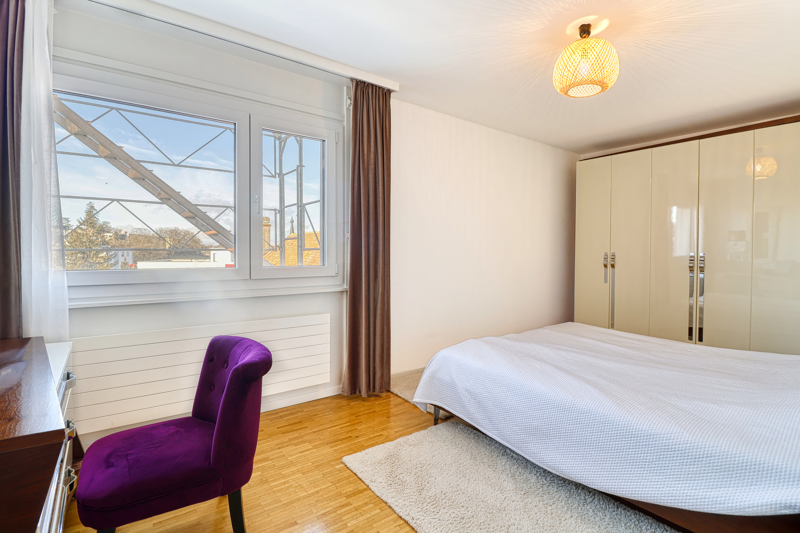 Helles Schlafzimmer mit Fenster und Kleiderschrank