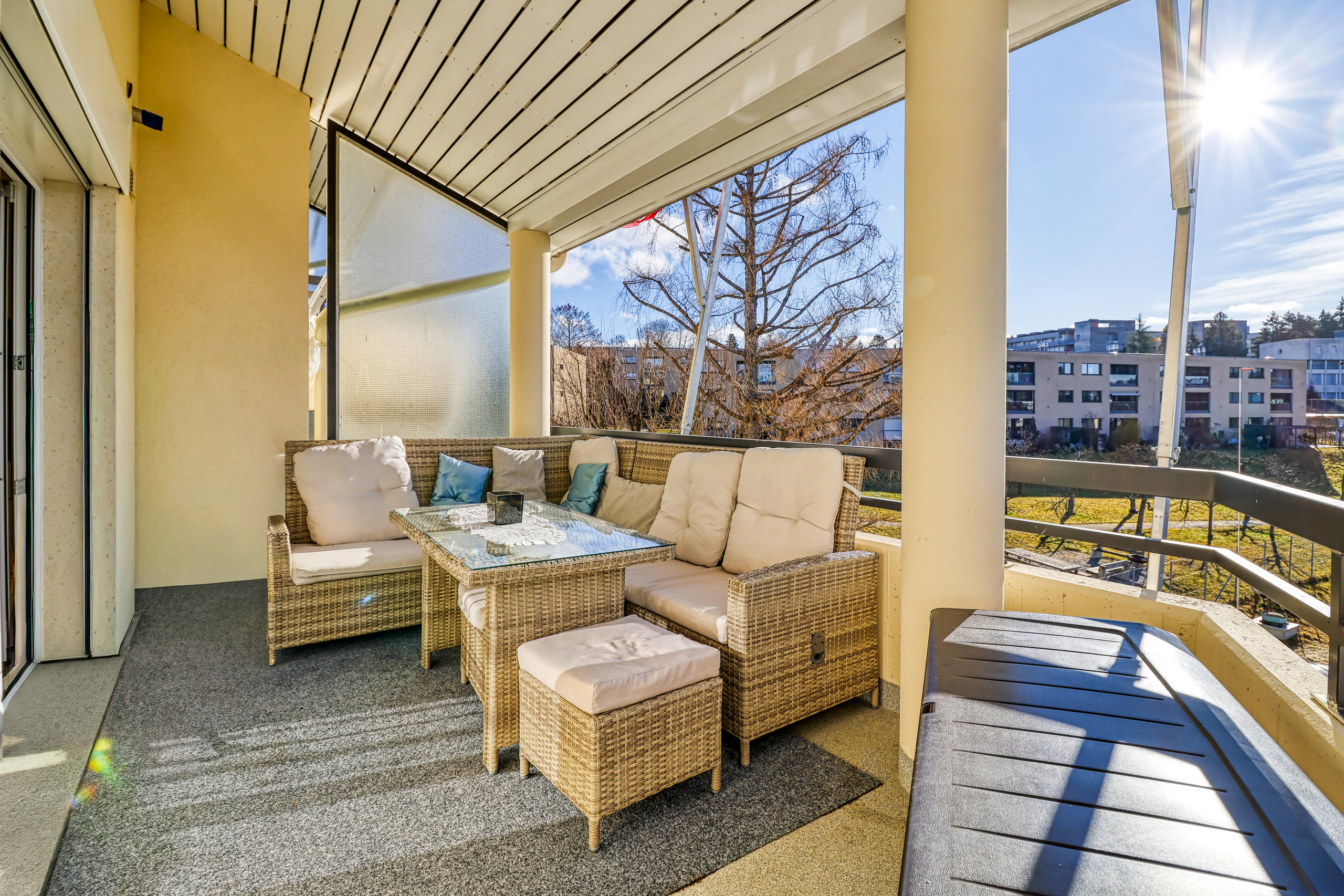 Überdachte Balkonterrasse mit Sitzgruppe