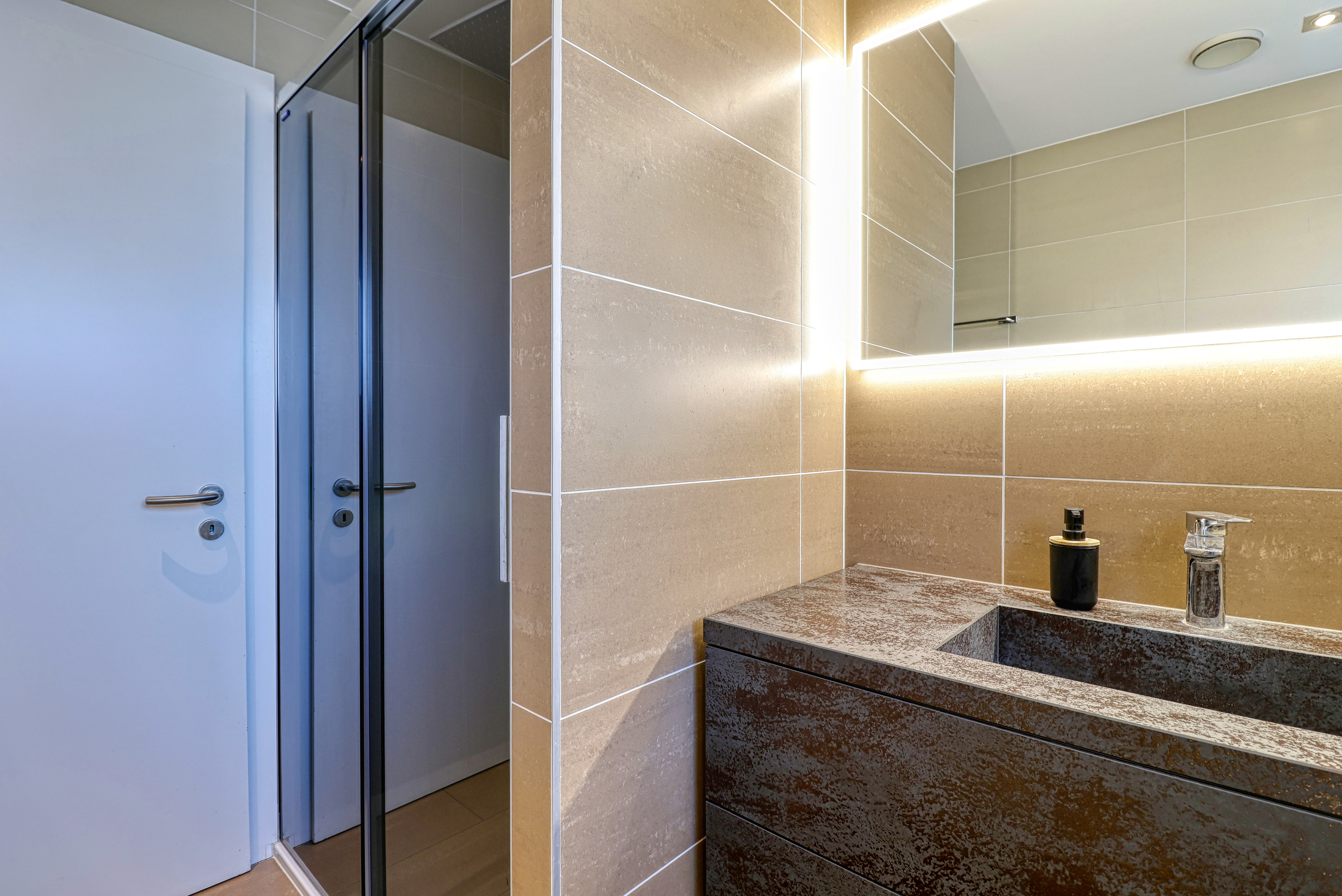 Modernes Badezimmer mit beleuchtetem Spiegel und begehbarer Dusche