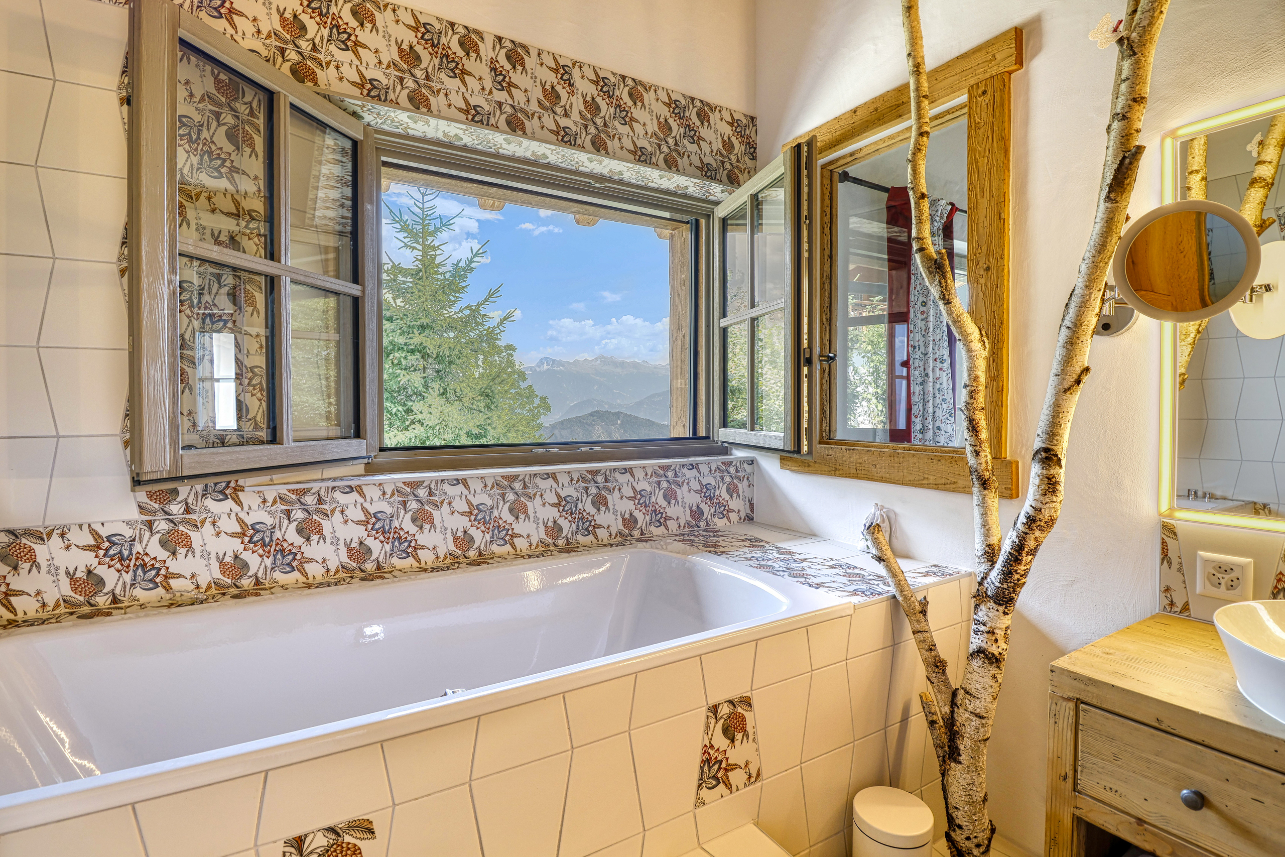 Badezimmer mit Fenster und Bergblick