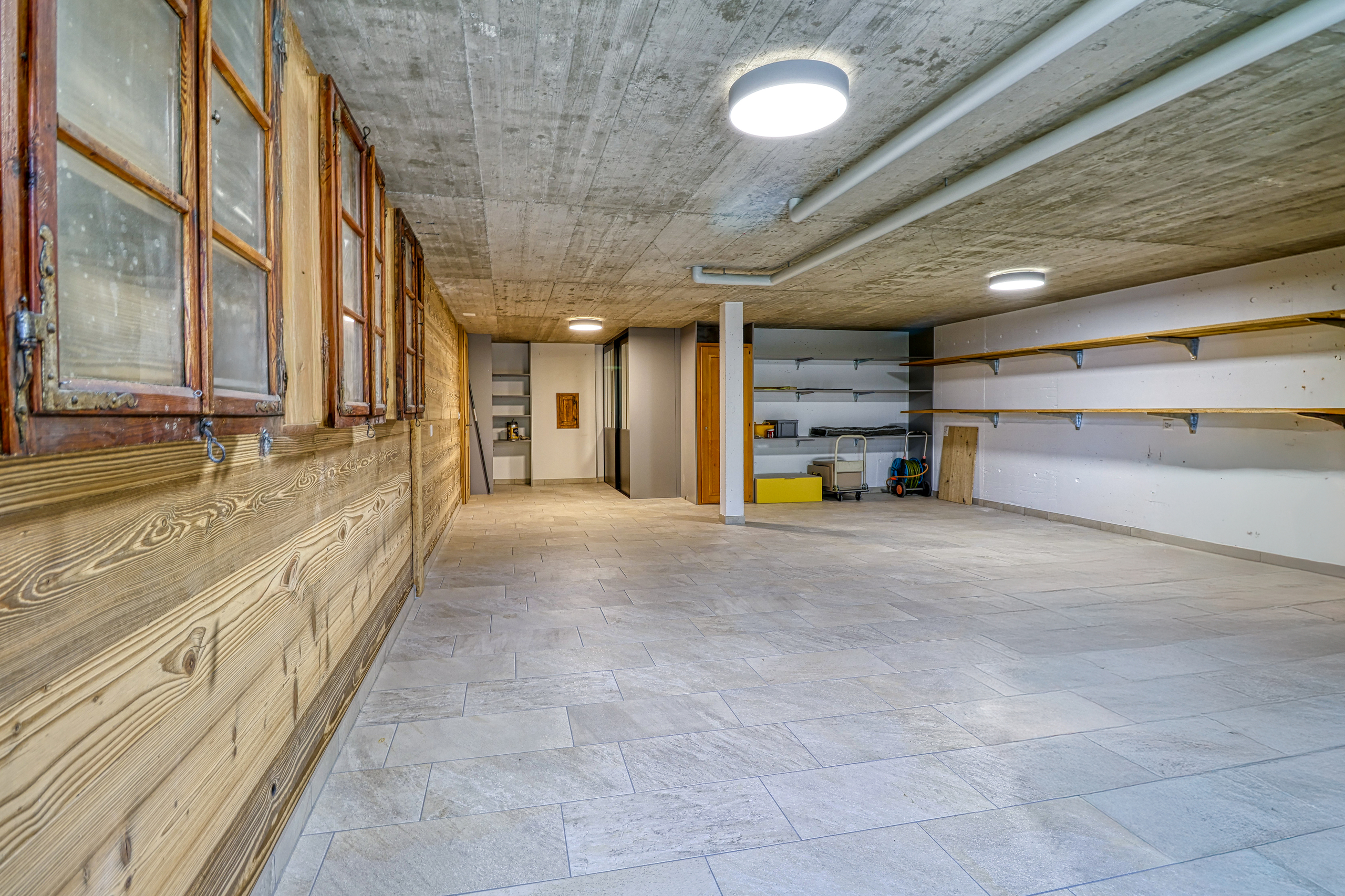 Großer Keller- oder Nebenraum mit Fliesenboden und Holzverkleidung