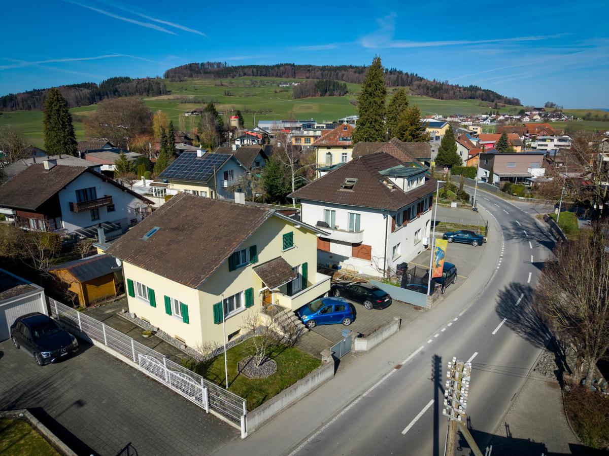 Wohngebiet aus der Luft mit Einfamilienhäusern und Hügelkulisse