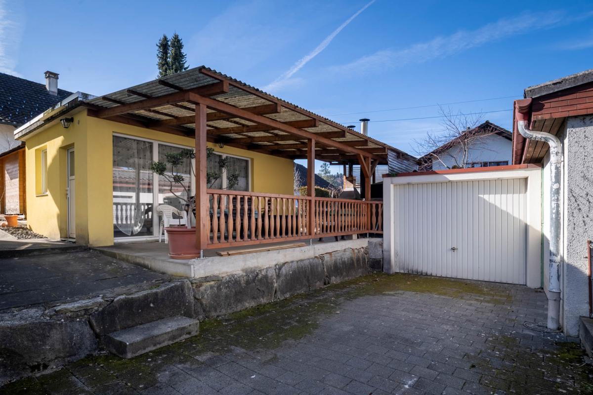 Außenbereich mit überdachter Terrasse und Garage