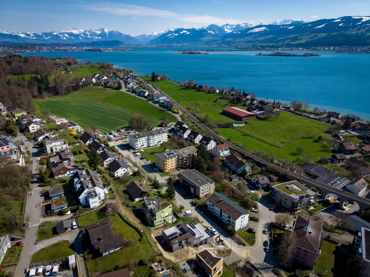 Luftaufnahme einer See- und Berglandschaft mit Wohngebiet