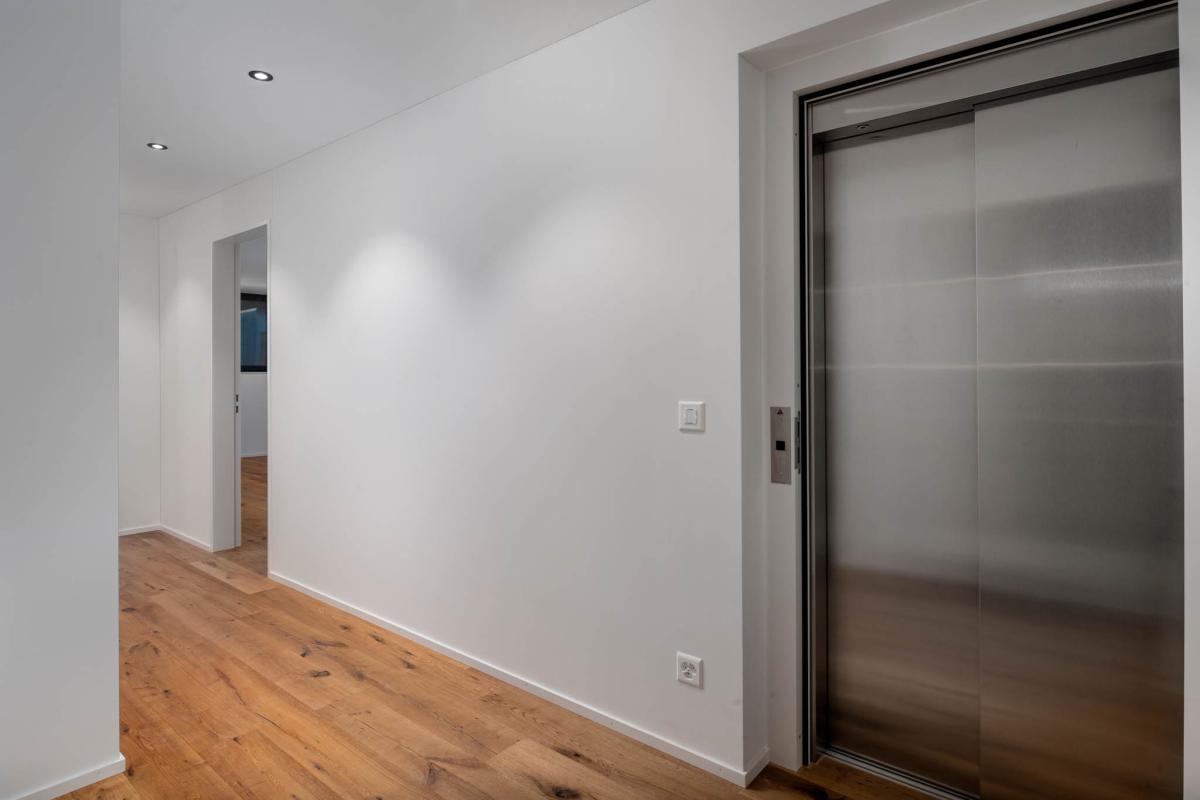 Moderner Flur mit Aufzug und Holzfußboden