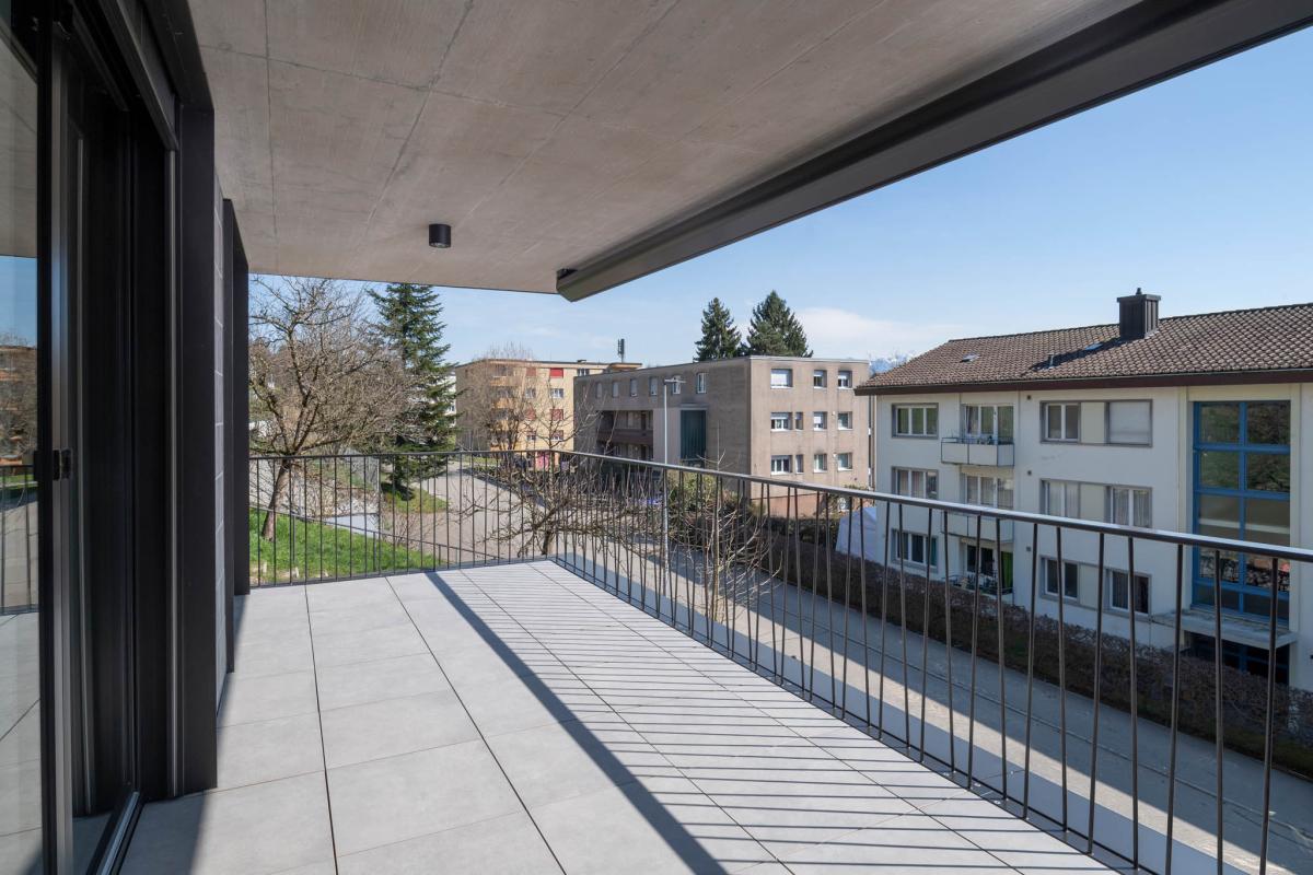 Überdachter Balkon mit Ausblick auf Wohngebäude