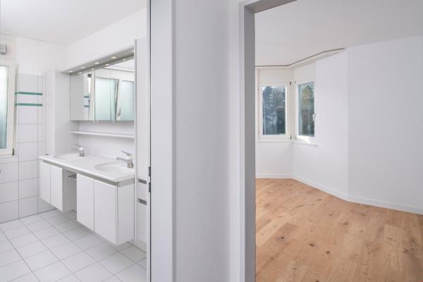 Helles Badezimmer neben leerem Zimmer