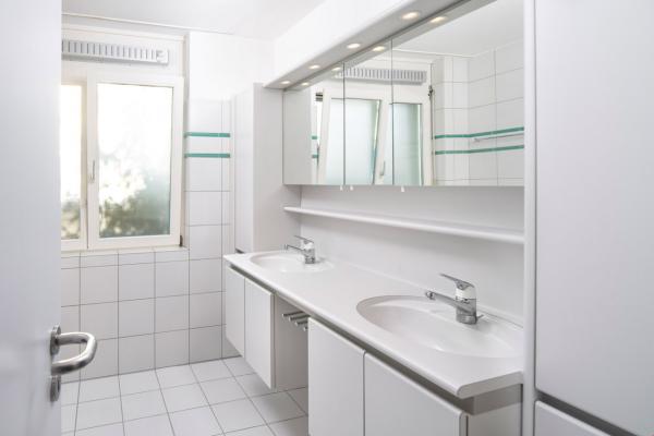 Helles Badezimmer mit Doppelwaschtisch und Spiegelschrank