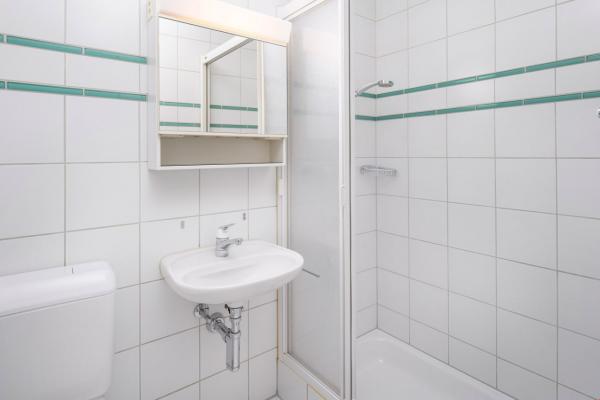 Kleines helles Badezimmer mit Dusche und Waschbecken