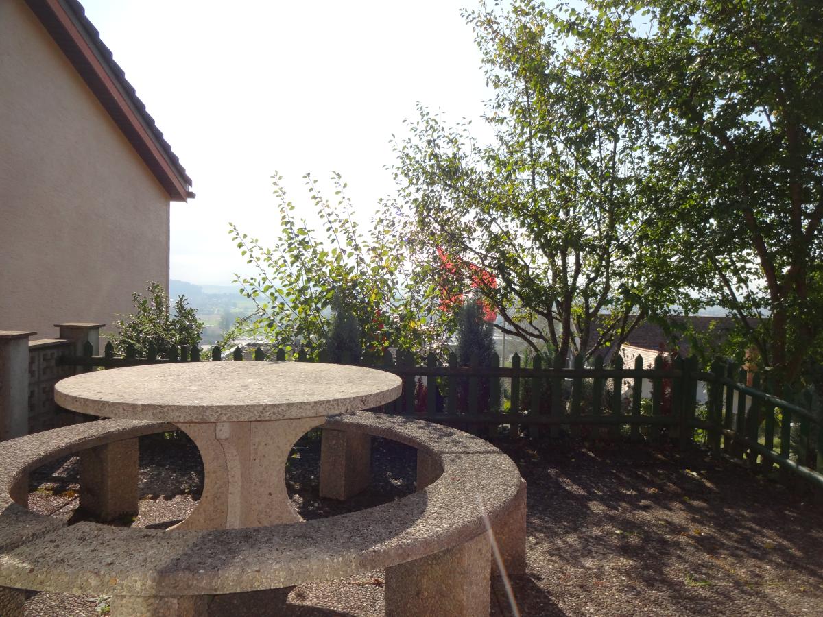 Terrasse mit Rundtisch und Gartenblick