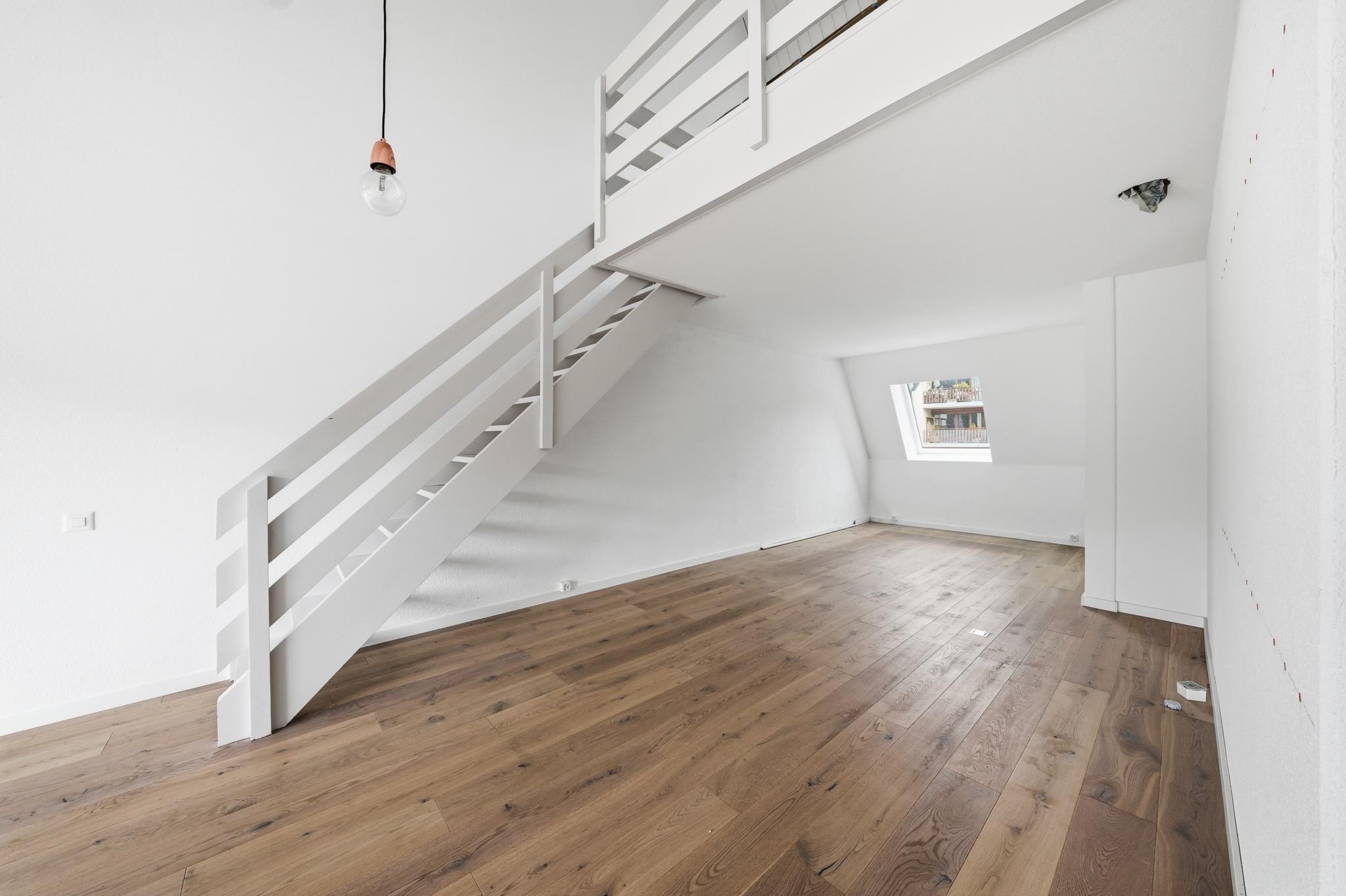 Helles Dachgeschosszimmer mit Galerie und Holzfußboden