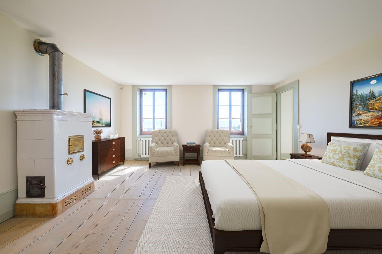 Helles Schlafzimmer mit Ofen und zwei Sesseln