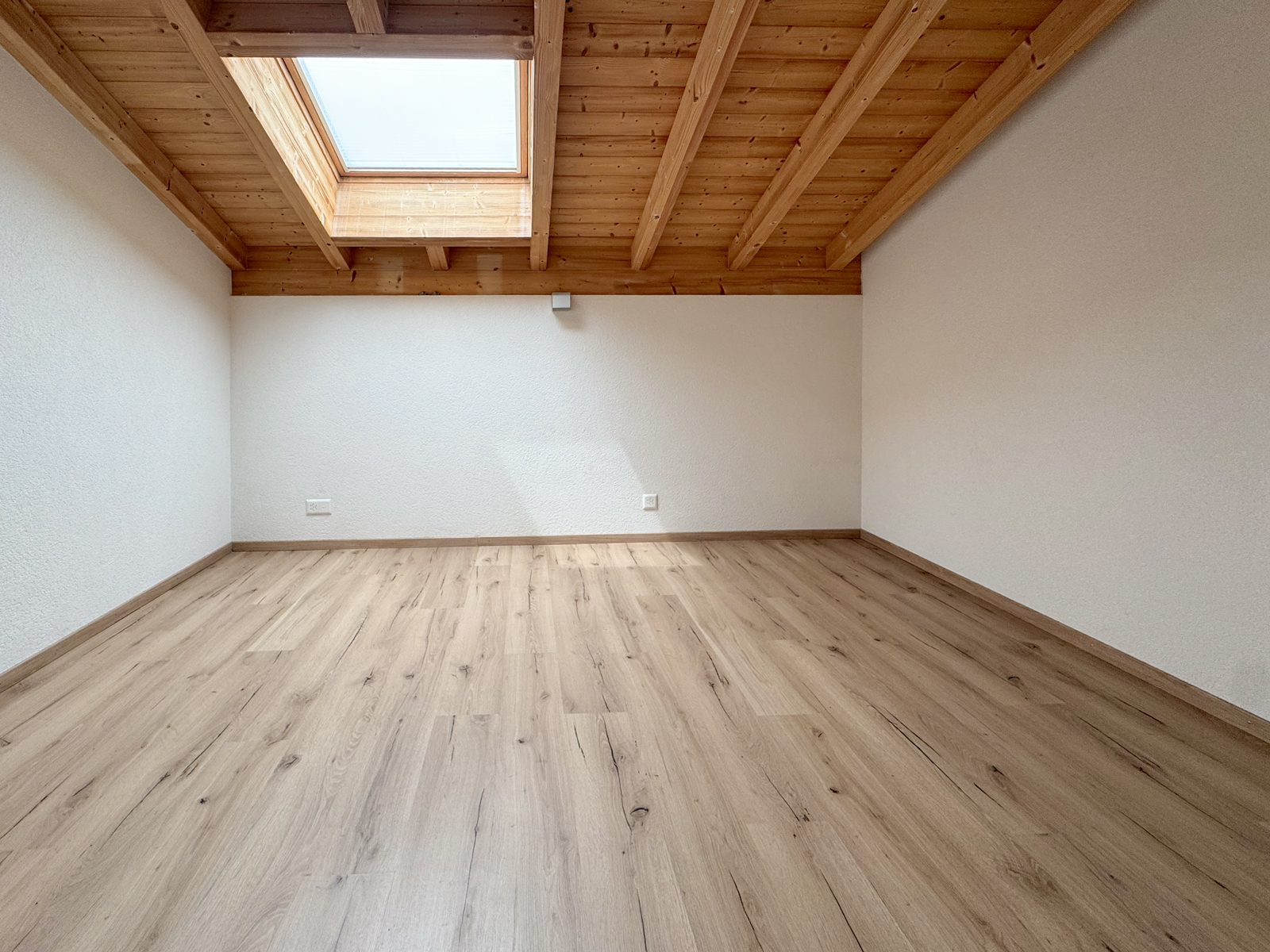 Leerer Dachraum mit Holzdecke und Dachfenster