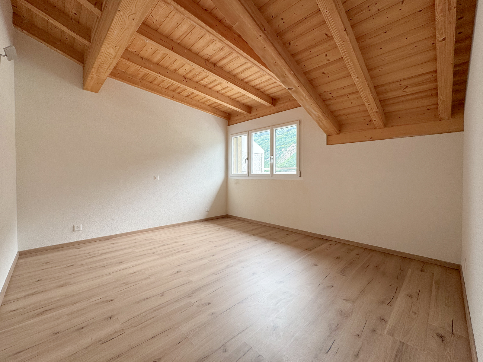 Heller Raum mit sichtbarer Holzbalkendecke