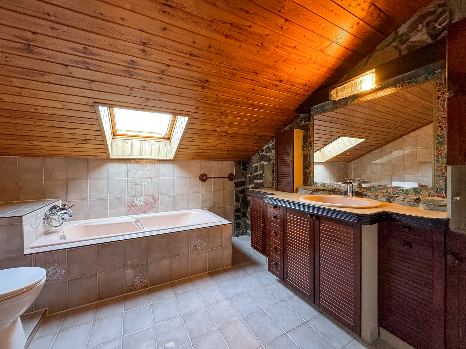 Rustikales Dachbad mit Wanne und Holzdecke