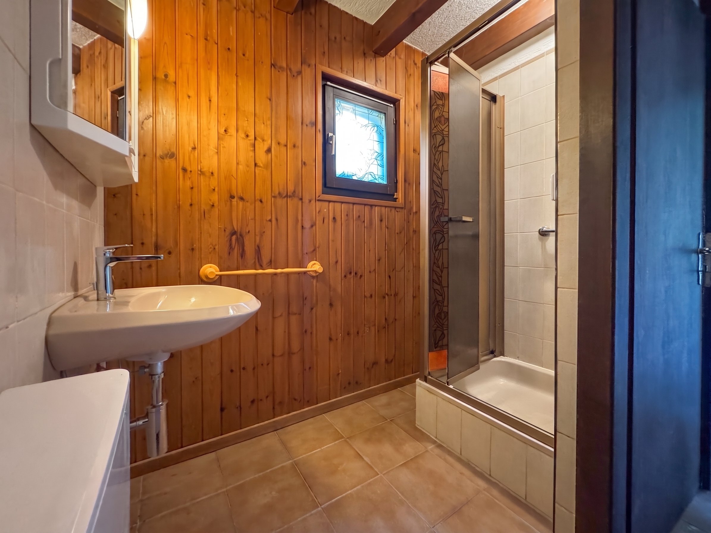 Rustikales Badezimmer mit Holzwand und Dusche