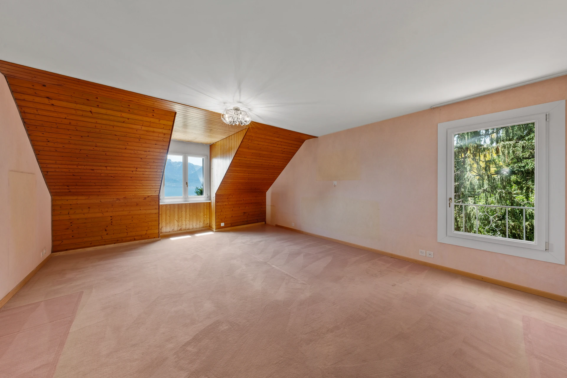 Leerer Dachgeschossraum mit Holzvertäfelung und Aussicht