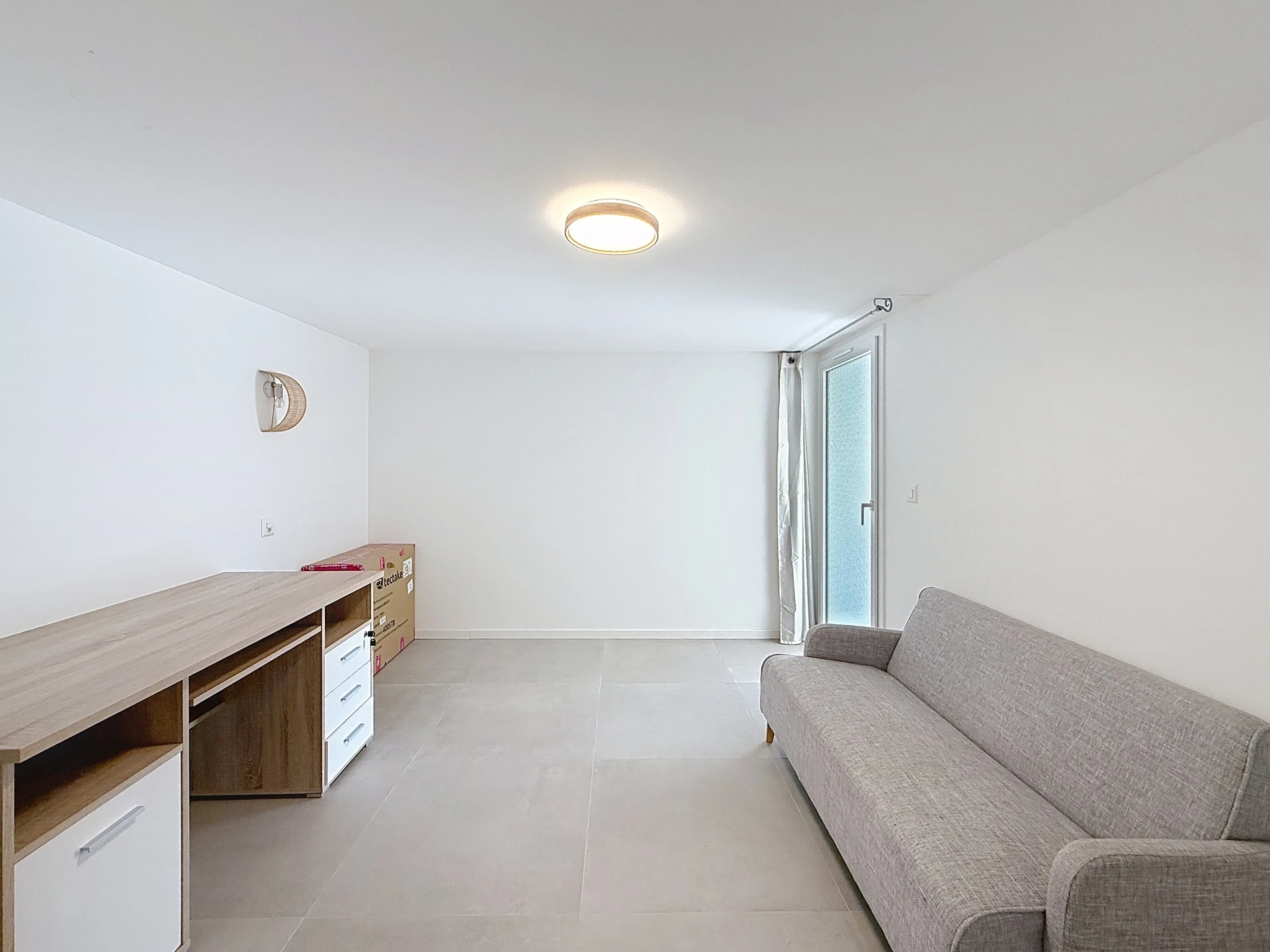 Helles, schlichtes Wohnzimmer mit Sofa und Sideboard