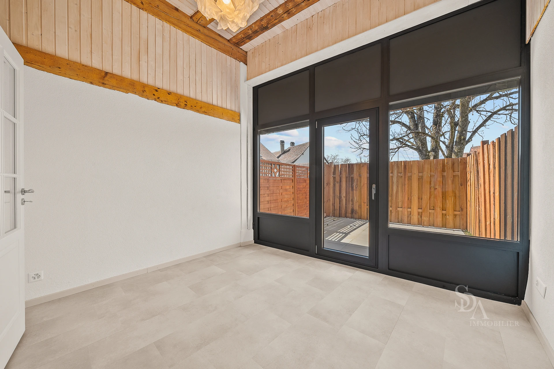 Heller Raum mit hoher Holzdecke und großer Schiebetür