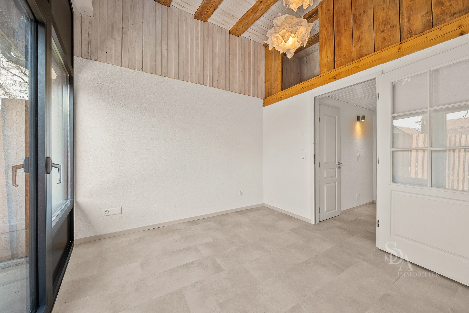 Heller Innenraum mit Holzdecke und großen Fenstern