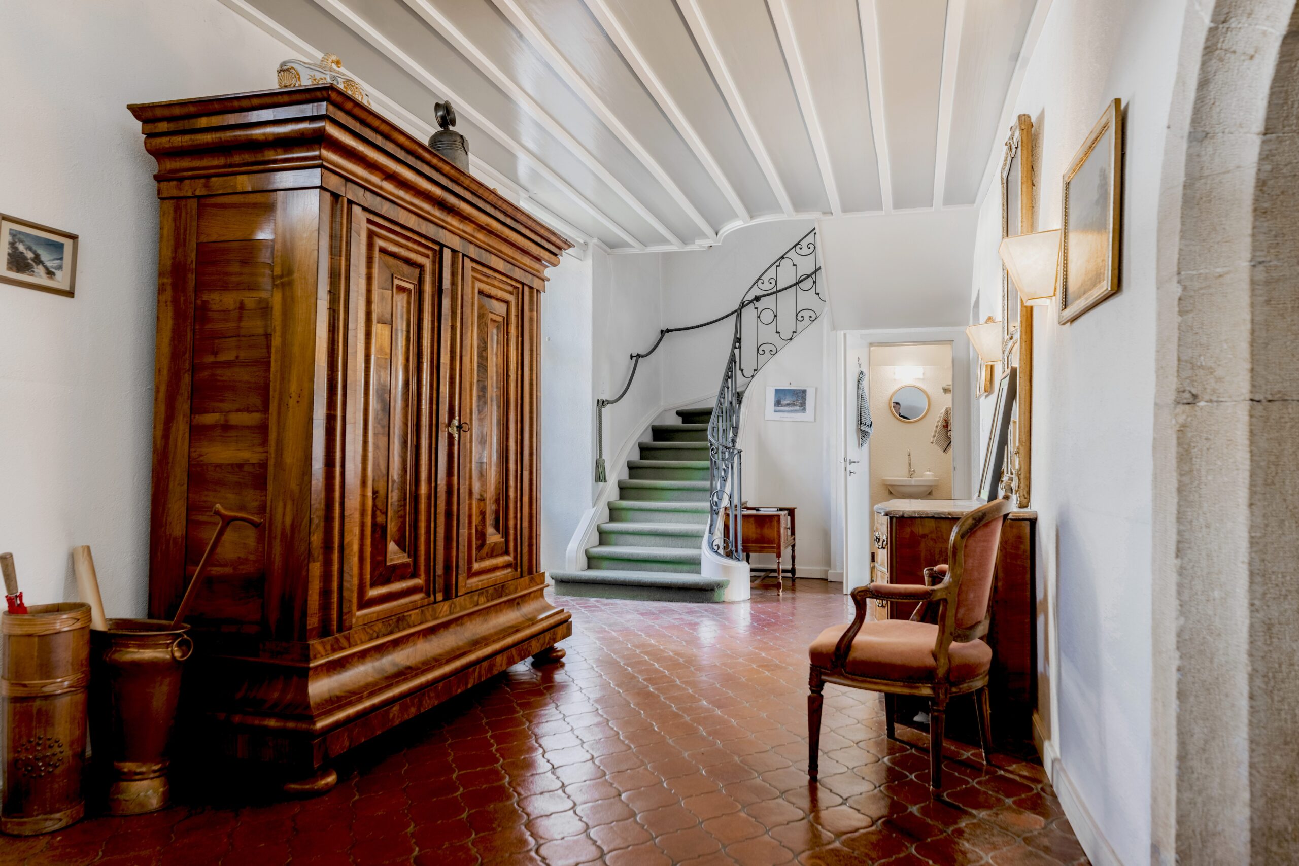 Historischer Flur mit Treppe und antiken Möbeln