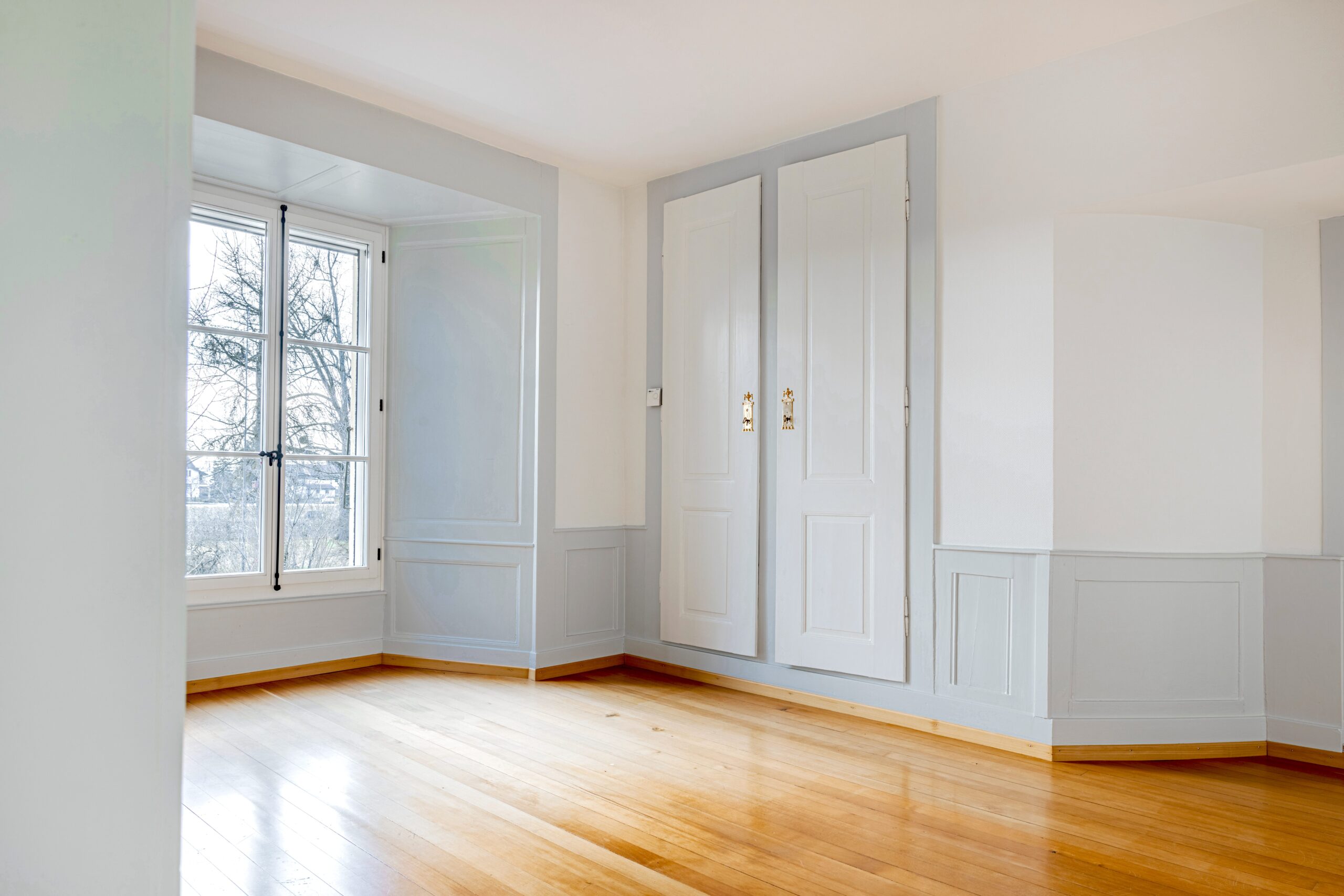 Heller Raum mit Holzboden und Doppelfenster