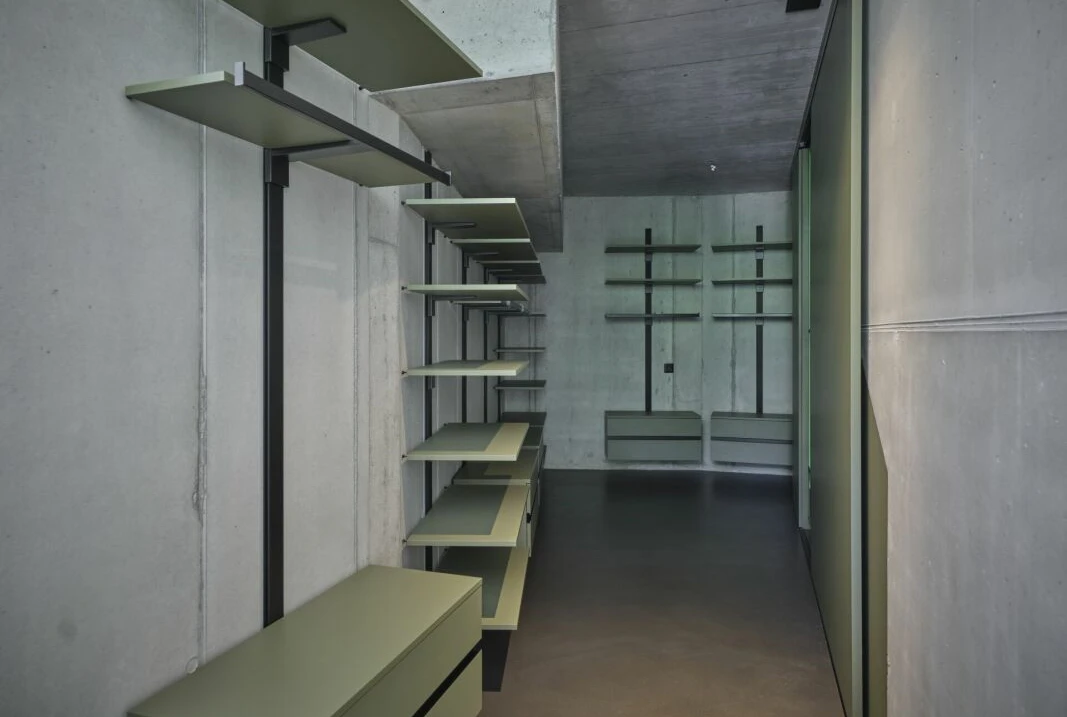Moderne begehbare Ankleide mit Betonoptik und offenen Regalen