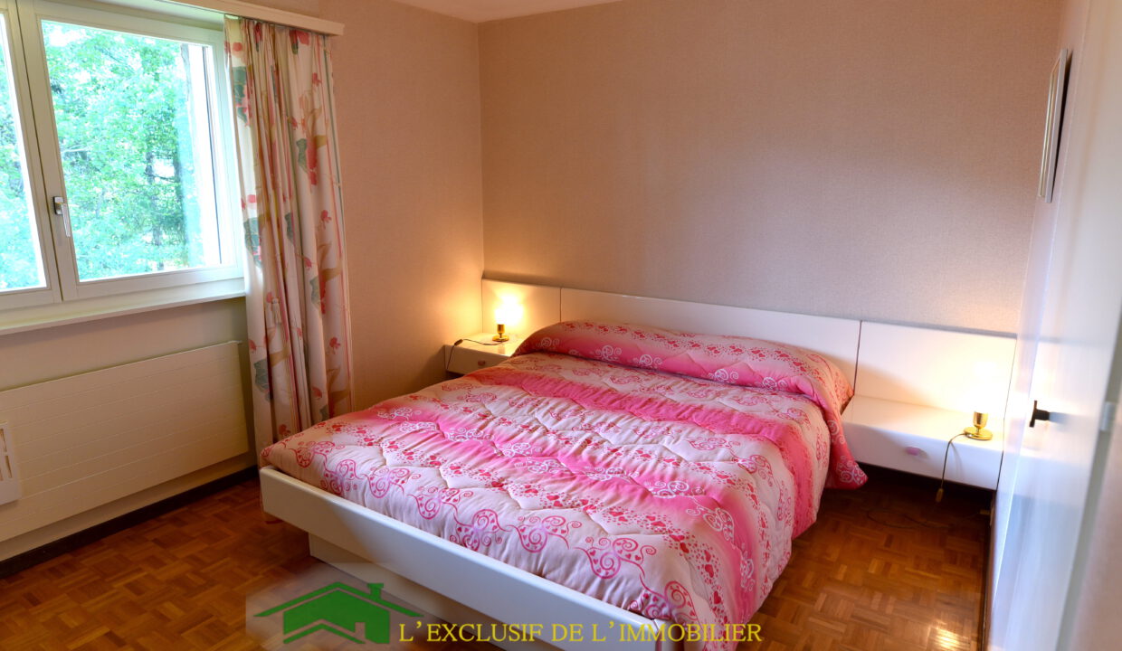 Schlafzimmer mit Doppelbett und Fensterblick
