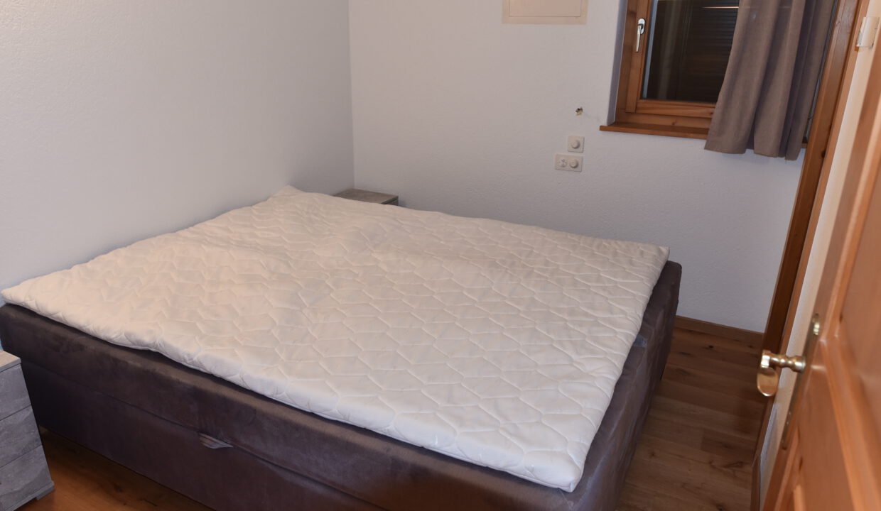 Kleines Schlafzimmer mit Bett und Fenster