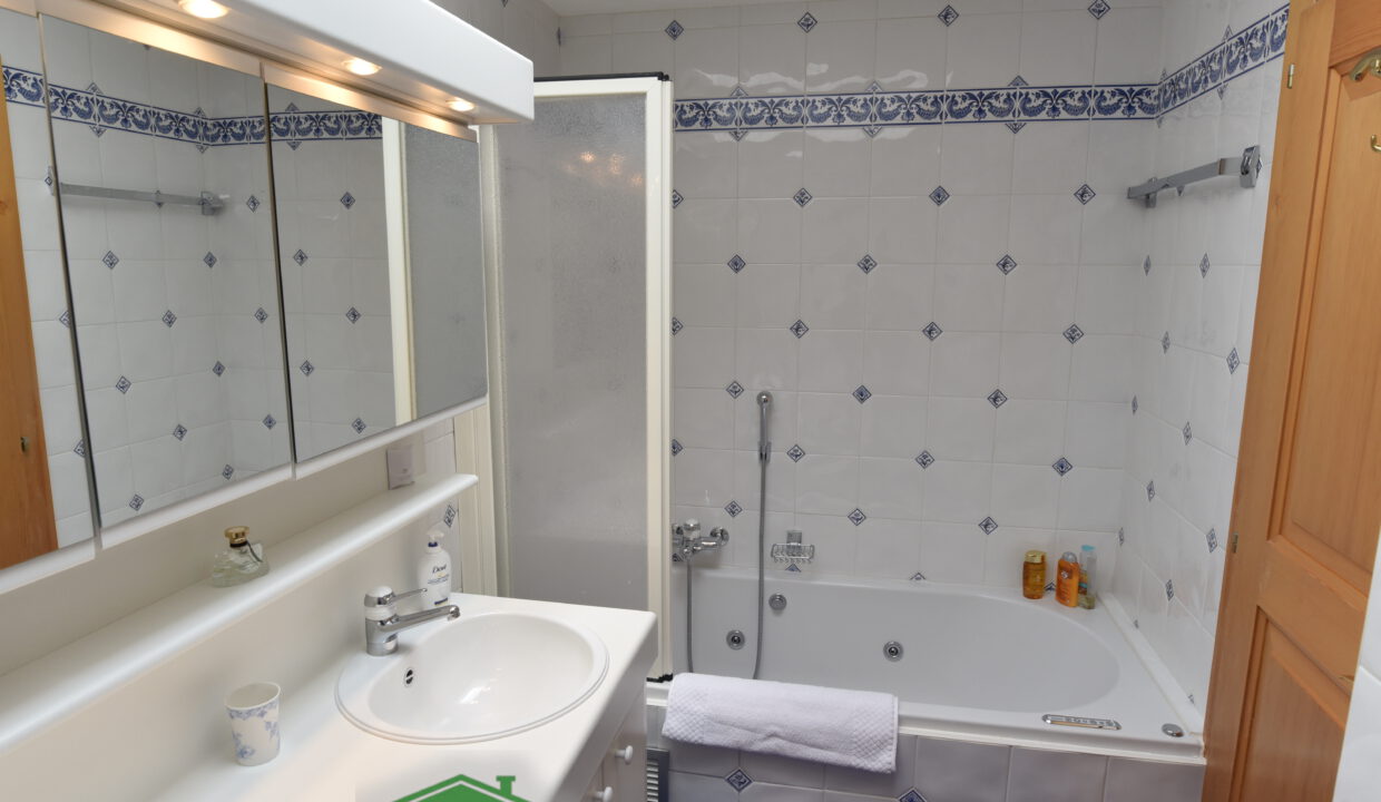 Badezimmer mit Wanne und Spiegelschrank
