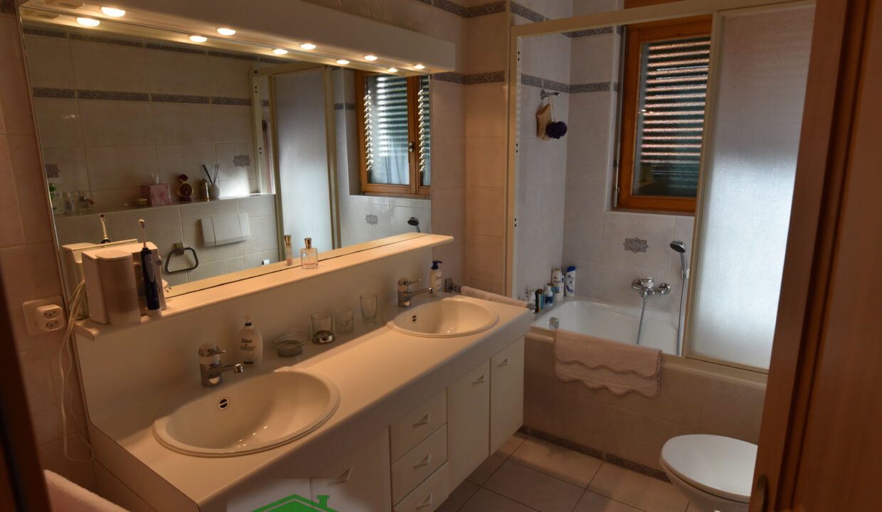 Badezimmer mit Doppelwaschtisch und Badewanne
